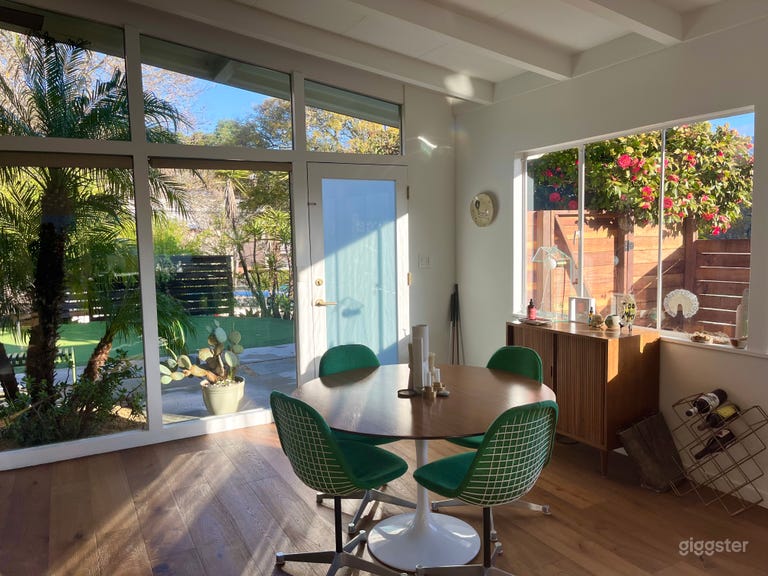  Dining area with original Herman Miller chairs and floor to ceiling windows overlooking the front yard 