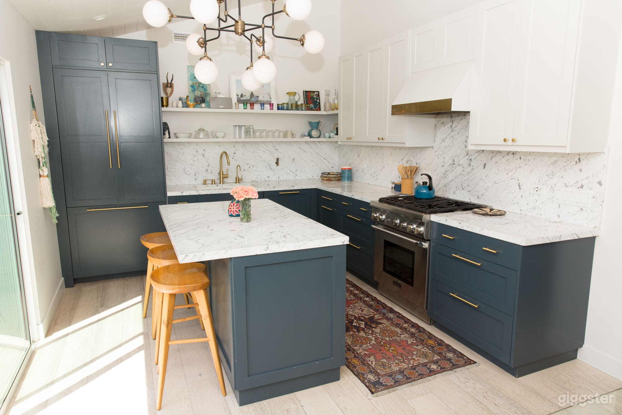 Modern kitchen with marble countertops, brass handles, beautiful light fixtures and great decor.