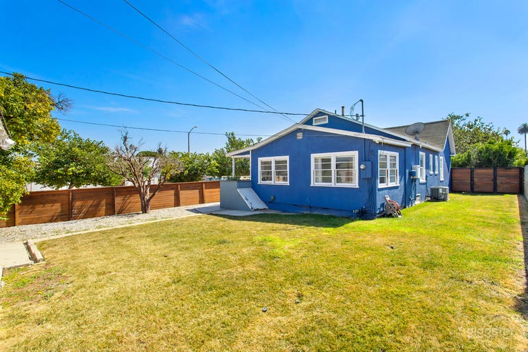  Wood Fenced-in yard with lush green grass   