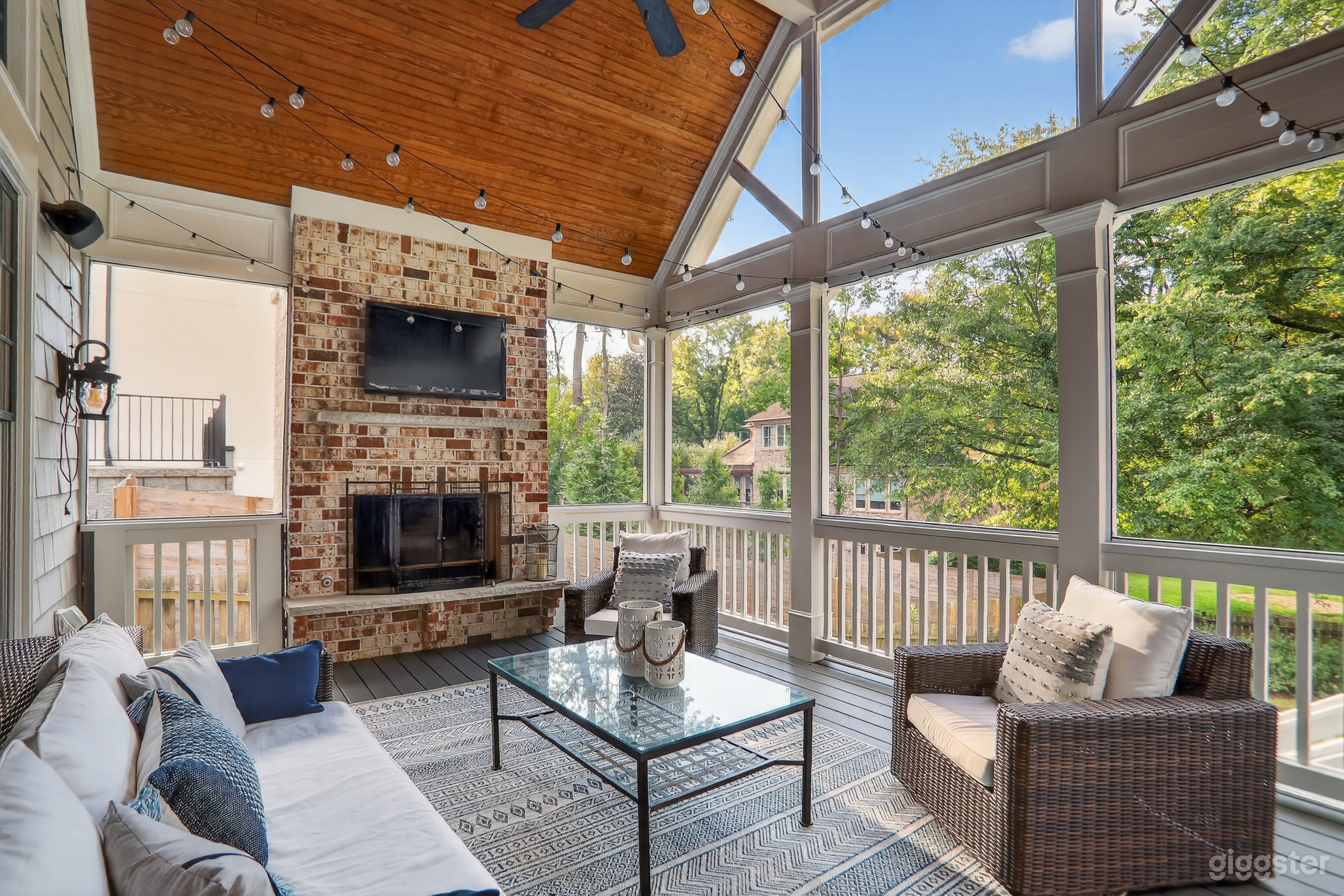 Large screened in back porch with wooden vaulted ceiling and brick fireplace