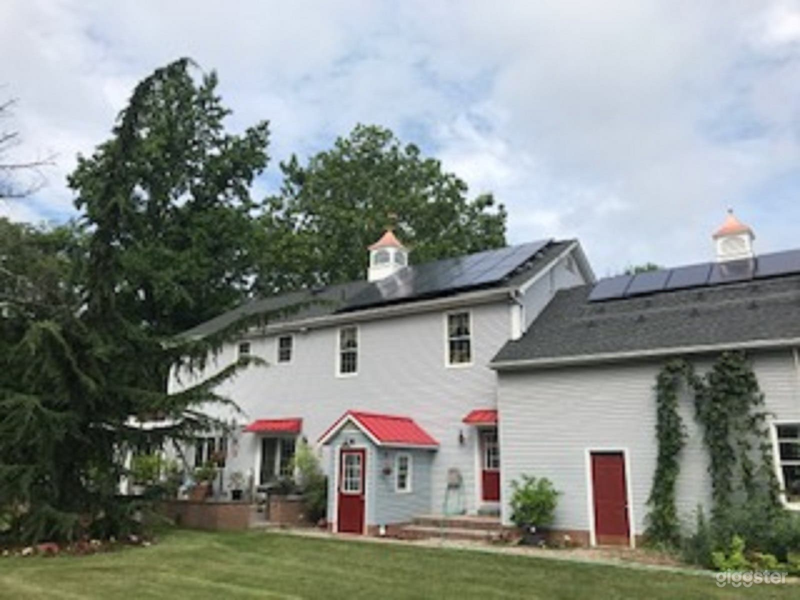 Rear view of home, including private entry to basement studio, shows 2 new cupolas
