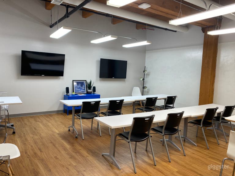  Small Conference Room with a high exposed ceiling and a large window looking into the atrium below. North wall has two mounted 70&quot; TVs 