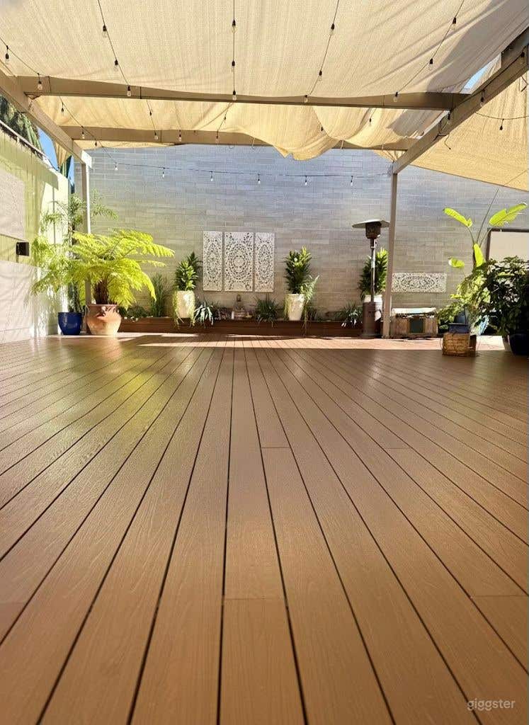  A serene outdoor deck with natural wood flooring and greenery—crafted for breathwork, mindful movement, and restorative rituals. 