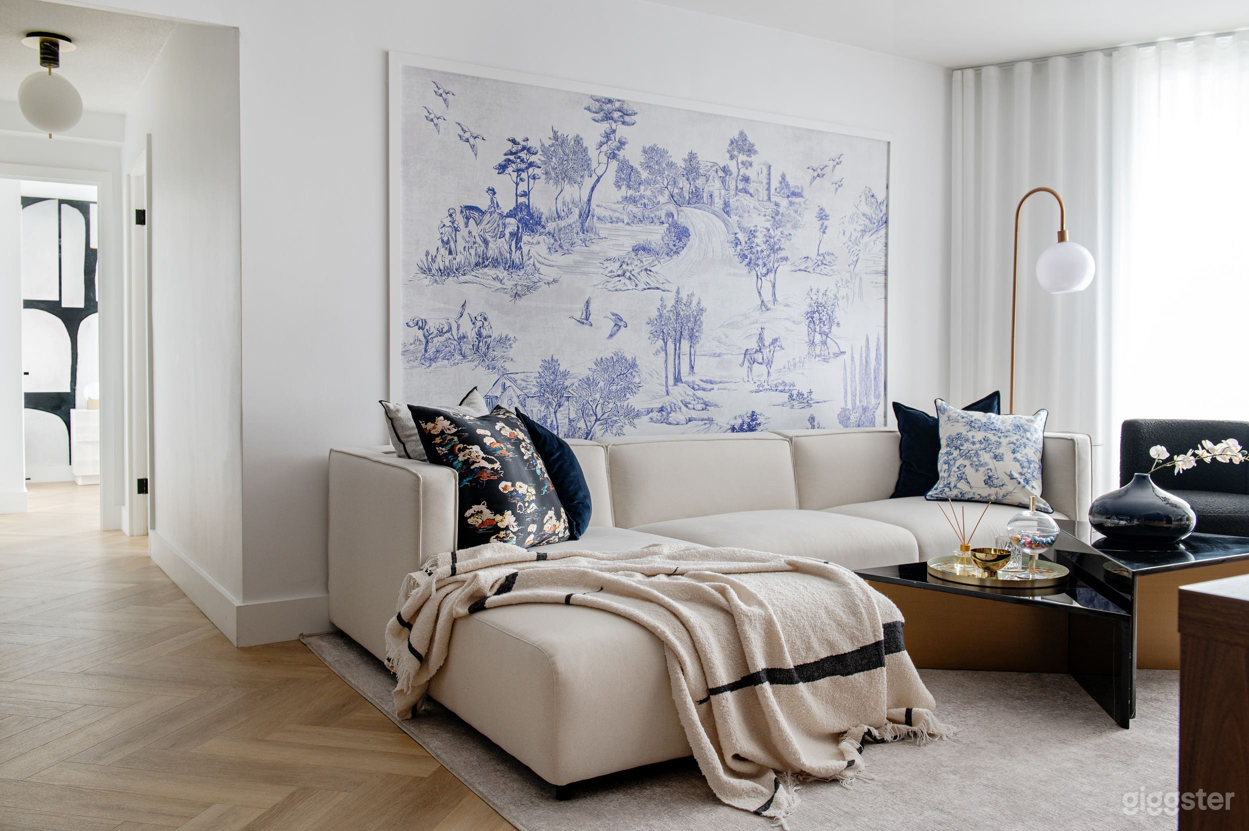 Living space with a cozy sectional sofa and an artistic wall mural