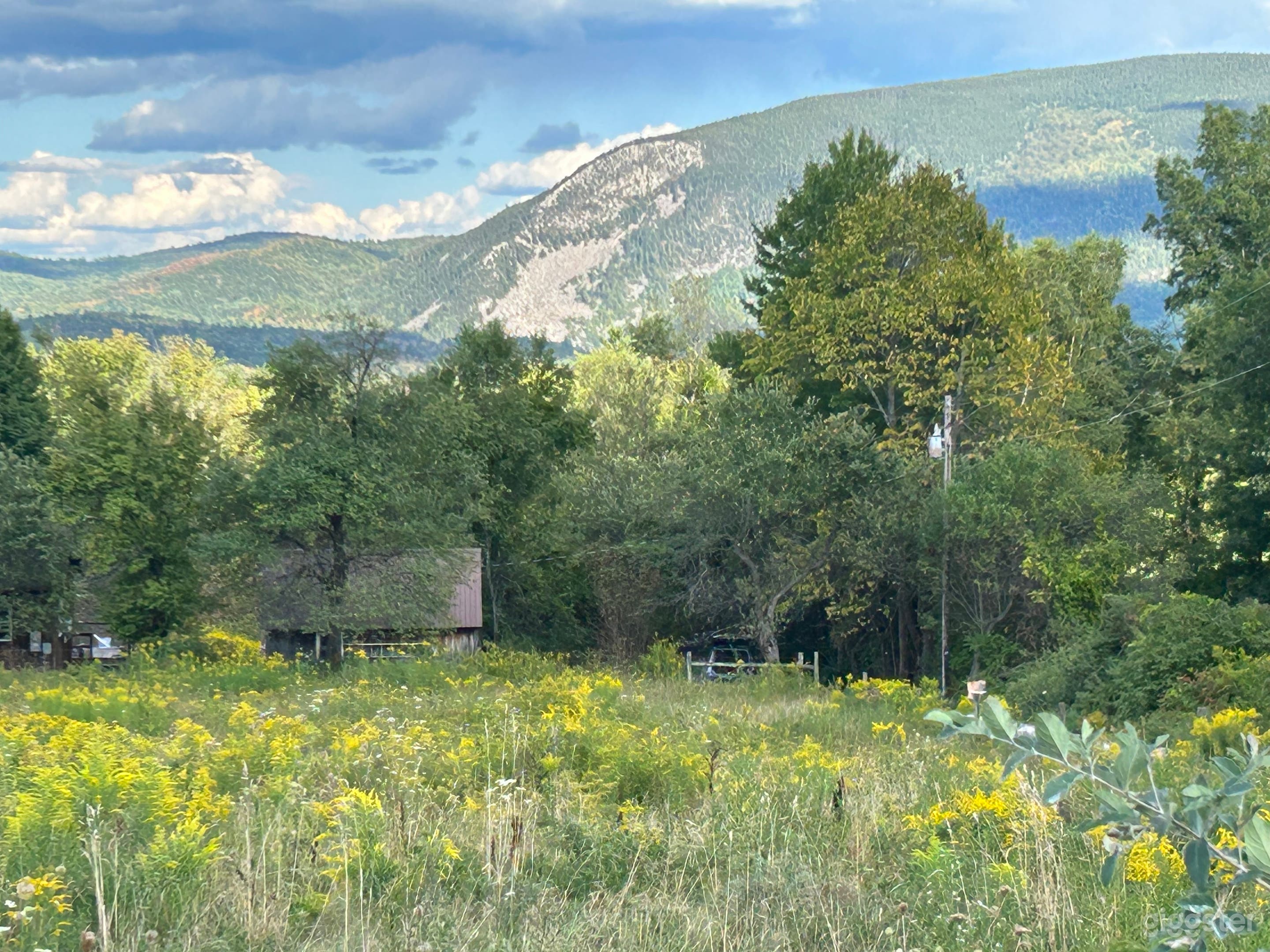 The house, barn and mountain view as seen from the head of the long gravel driveway leading to the property