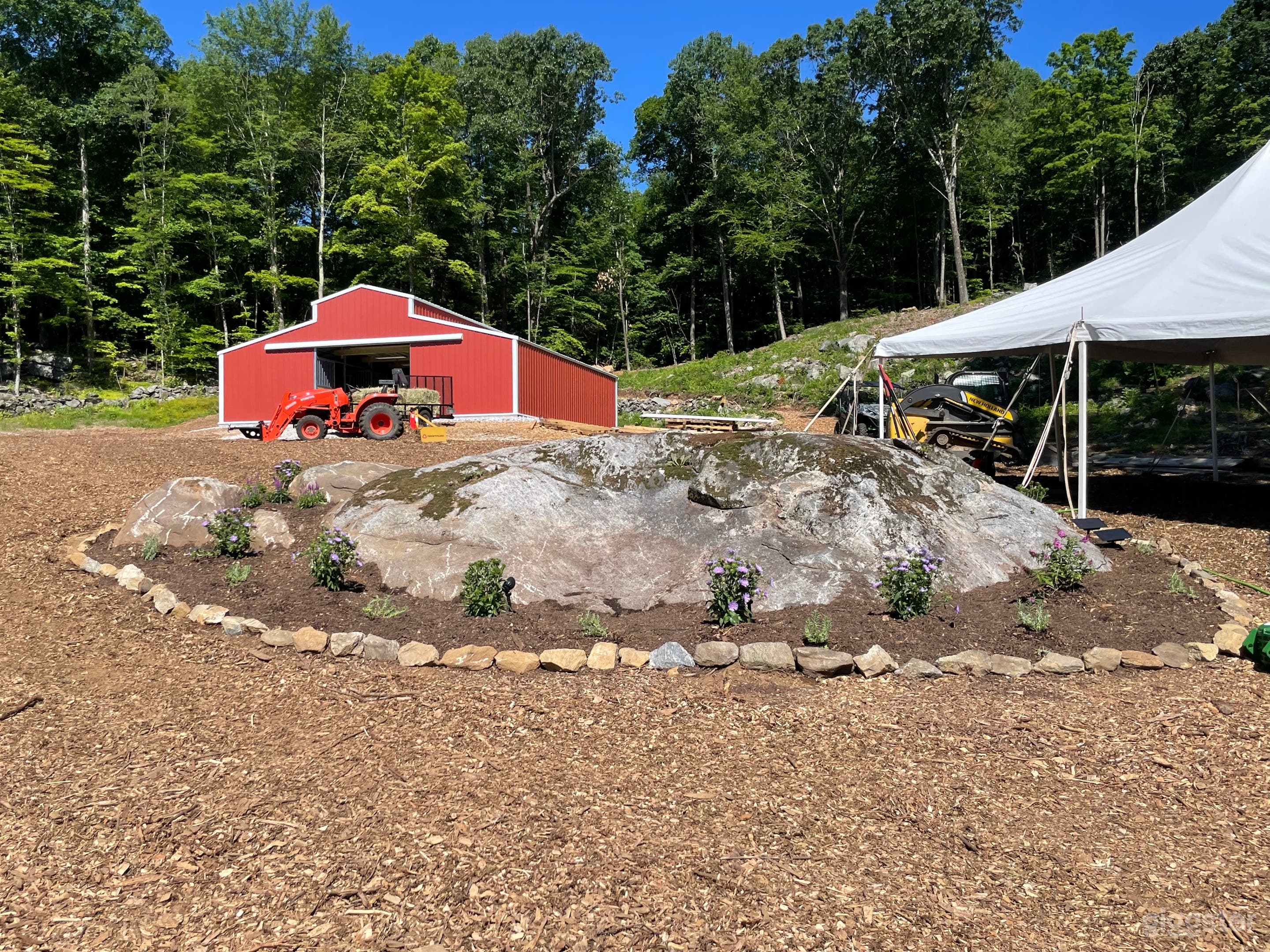 When you pull up to the top of the driveway you can see the landscaping, barn (which now has doors) and the forest behind it.