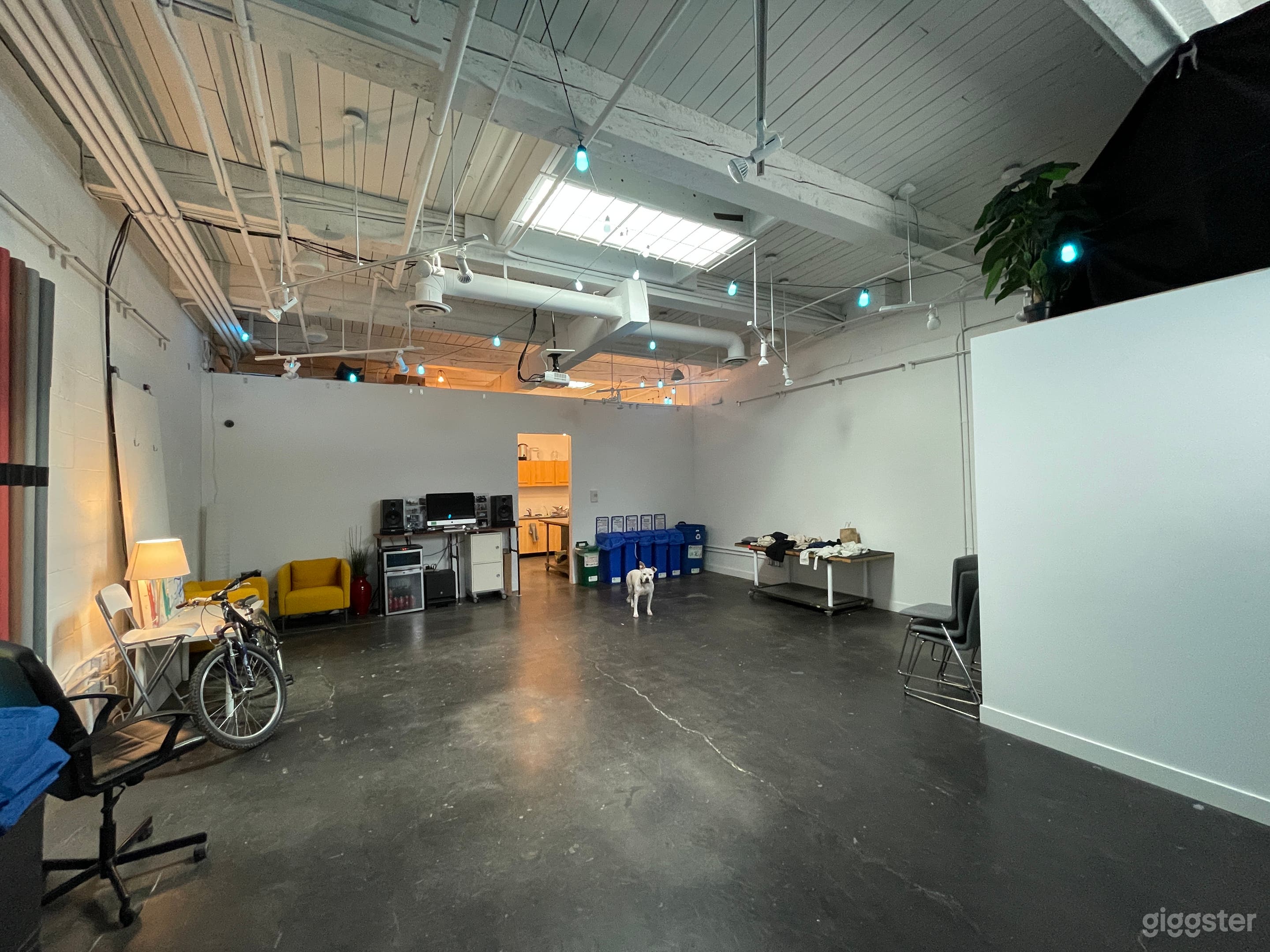 Studio space includes projector, speakers, recycling, tables and chairs.