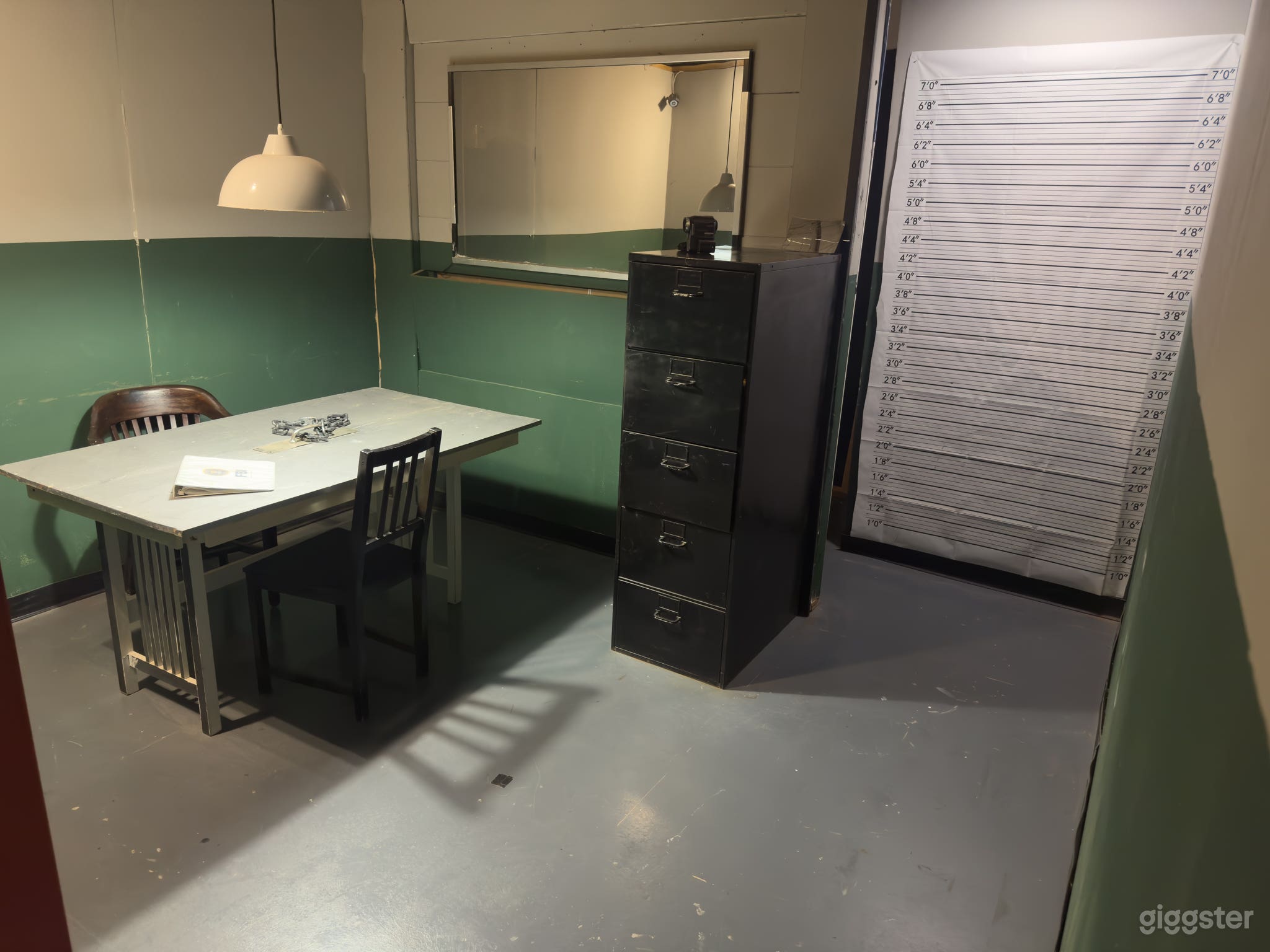 Interrogation room features a holding room with a one-way mirror, line up, and booking area.