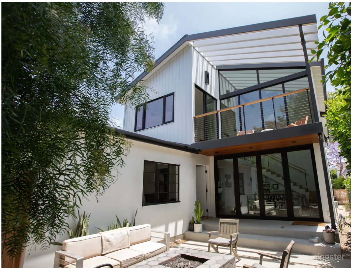 Front of the house with gas fire pit and seating area. The black doors open fully for an indoor/outdoor vibe.