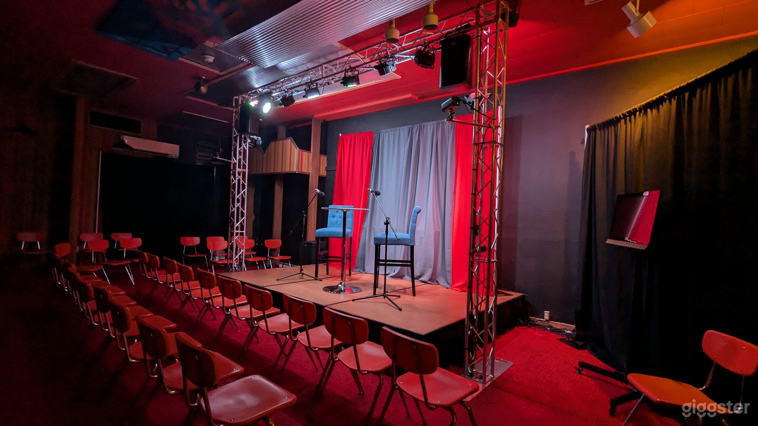 Angled view of the stage with lights on, curtains closed