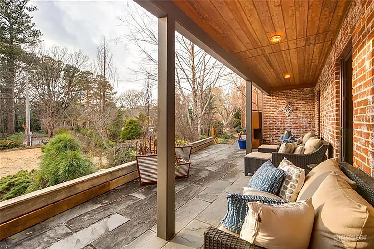 Blue stone front porch with glass doors and walkway. 