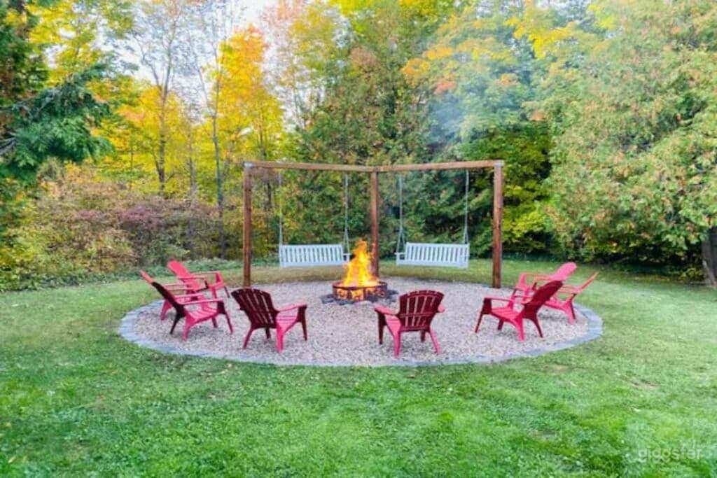 The outdoor living space offers spectacular views of the gardens and riverfront and includes a fire pit area with Muskoka chairs.
