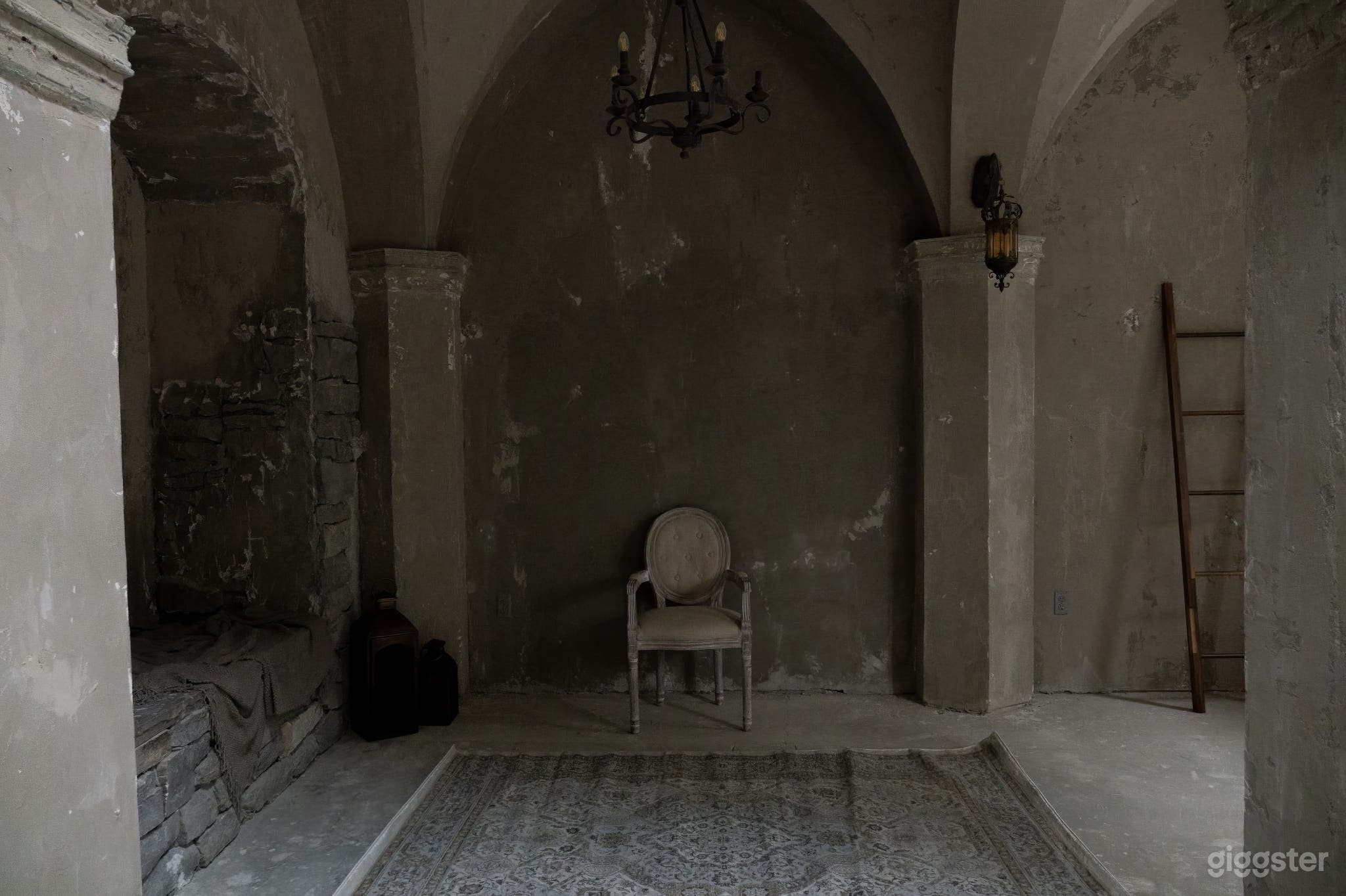 Medieval studio room featuring a chair amidst gray plaster walls, exuding authentic medieval ambiance