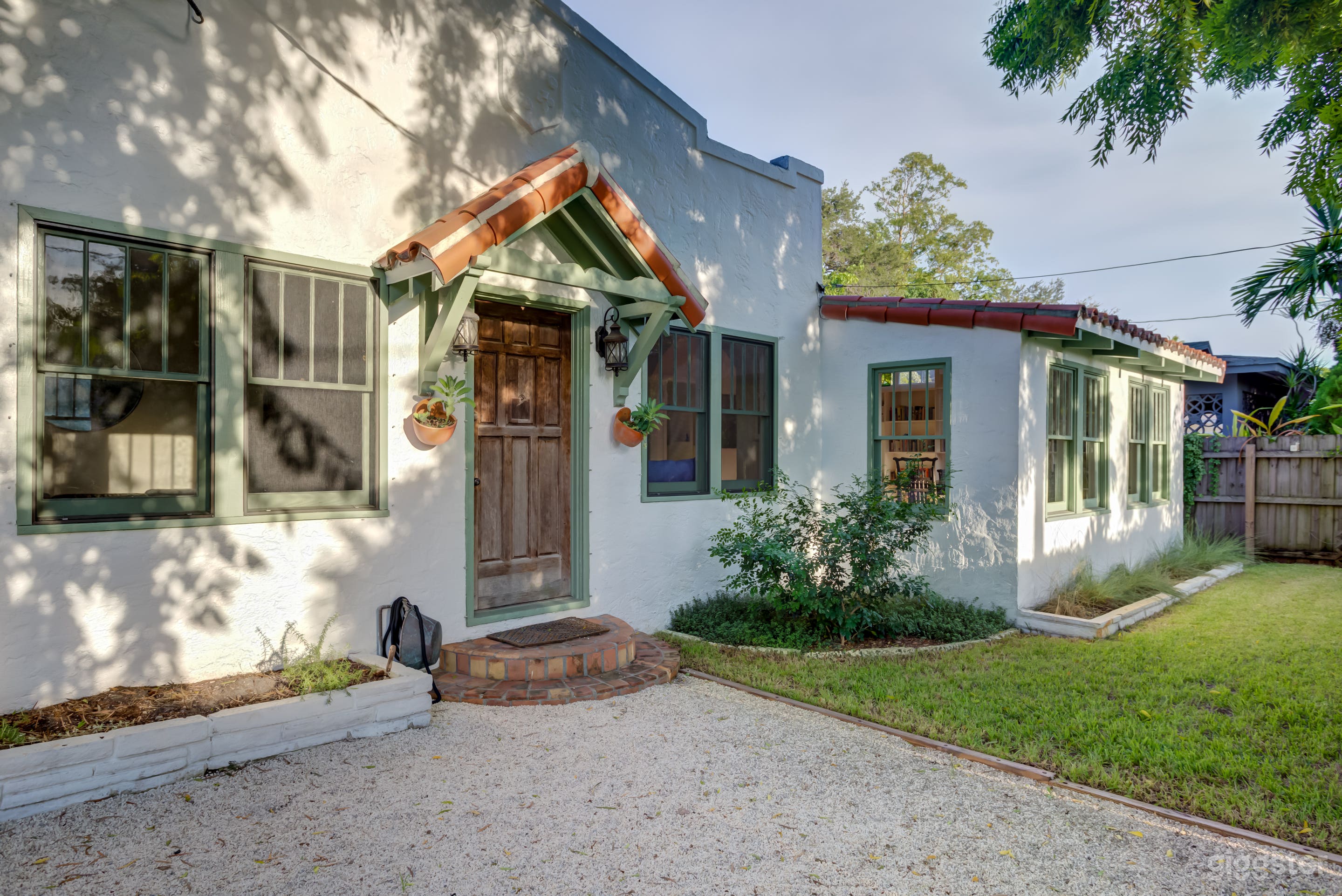 West-facing entrance to the home with small pea-stone driveway and walkway.  
