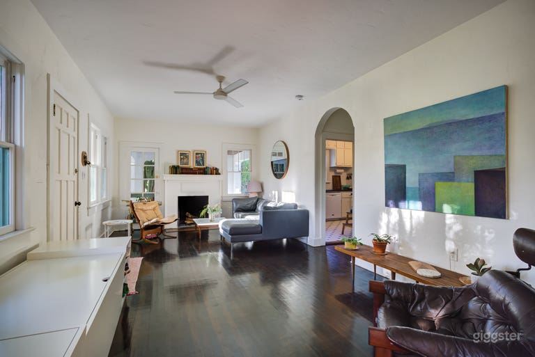  The living area with working fireplace and original dark-stained hardwood floors.  