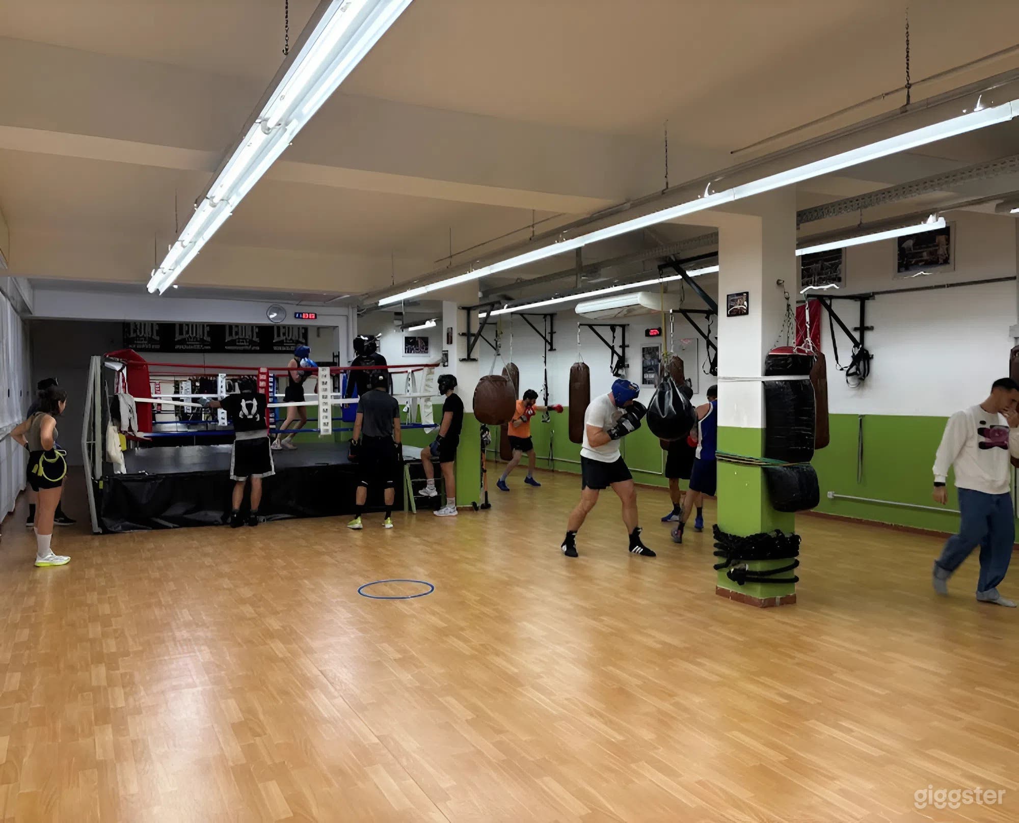Foto di Palestra di Pugilato Industriale con Ring, Zone di Allenamento e Atmosfera Urbana 3
