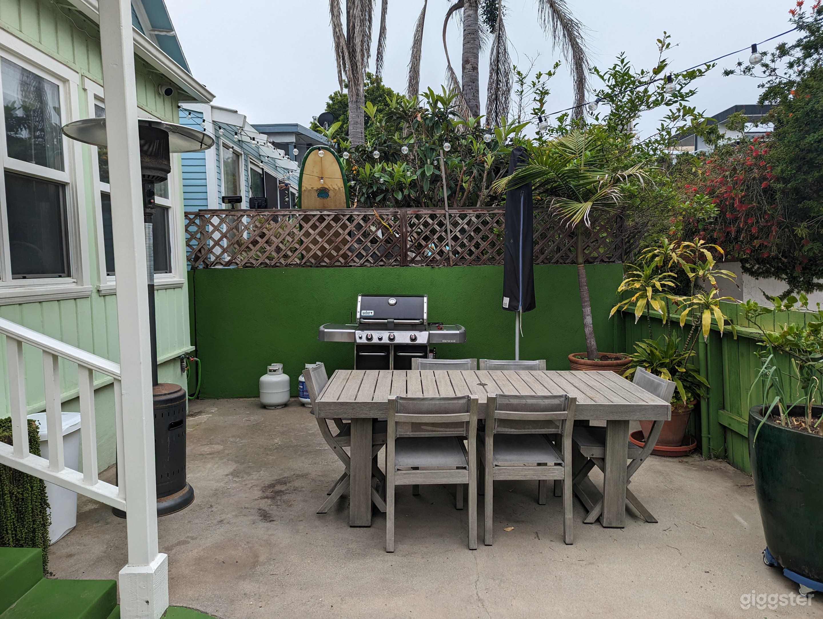 One side of the front yard with BBQ and table