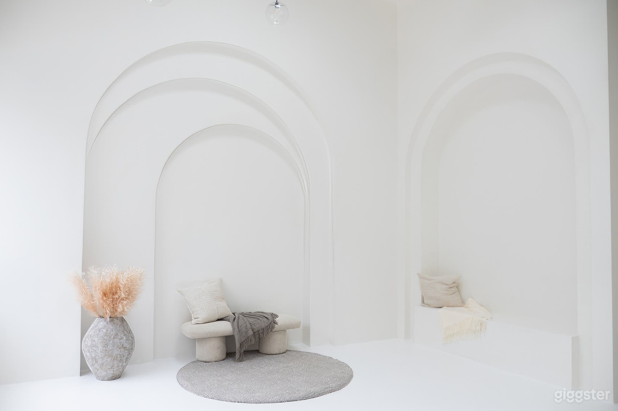 Photo studio space with captivating white, light, and airy boho vibes, accentuated by charming arches.