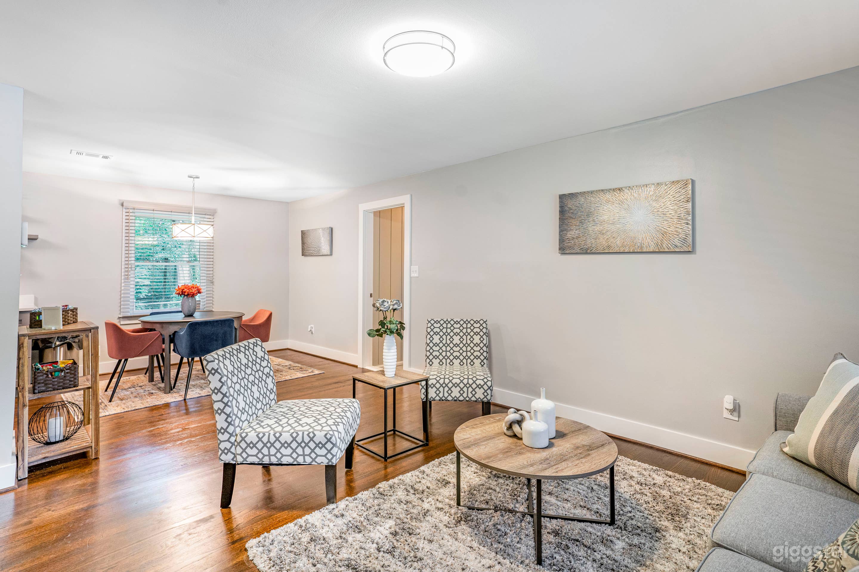 COMPLETELY FURNISHED LIVING ROOM WITH CLEAN LINES, DETAILED DECOR WITH ACCENTS, FINE ART, LARGE COUCH AND TWO ACCENT CHAIRS, COFFEE TABLE, END TABLE, CONSOLE AND OPEN CONCEPT TO THE EAT IN KITCHEN DIRECTLY BEHIND