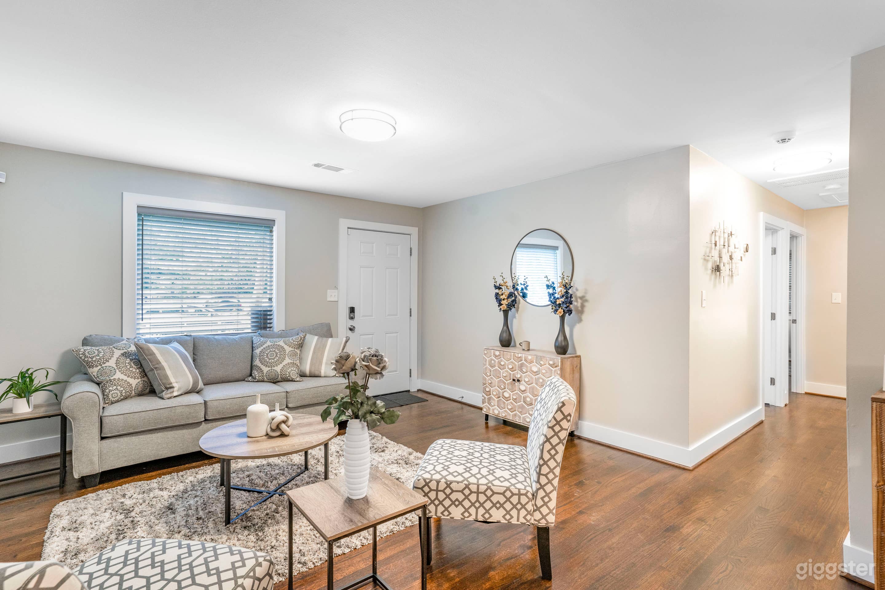 COMPLETELY FURNISHED LIVING ROOM WITH CLEAN LINES, DETAILED DECOR WITH ACCENTS, FINE ART, LARGE COUCH AND TWO ACCENT CHAIRS, COFFEE TABLE, END TABLE AND CONSOLE