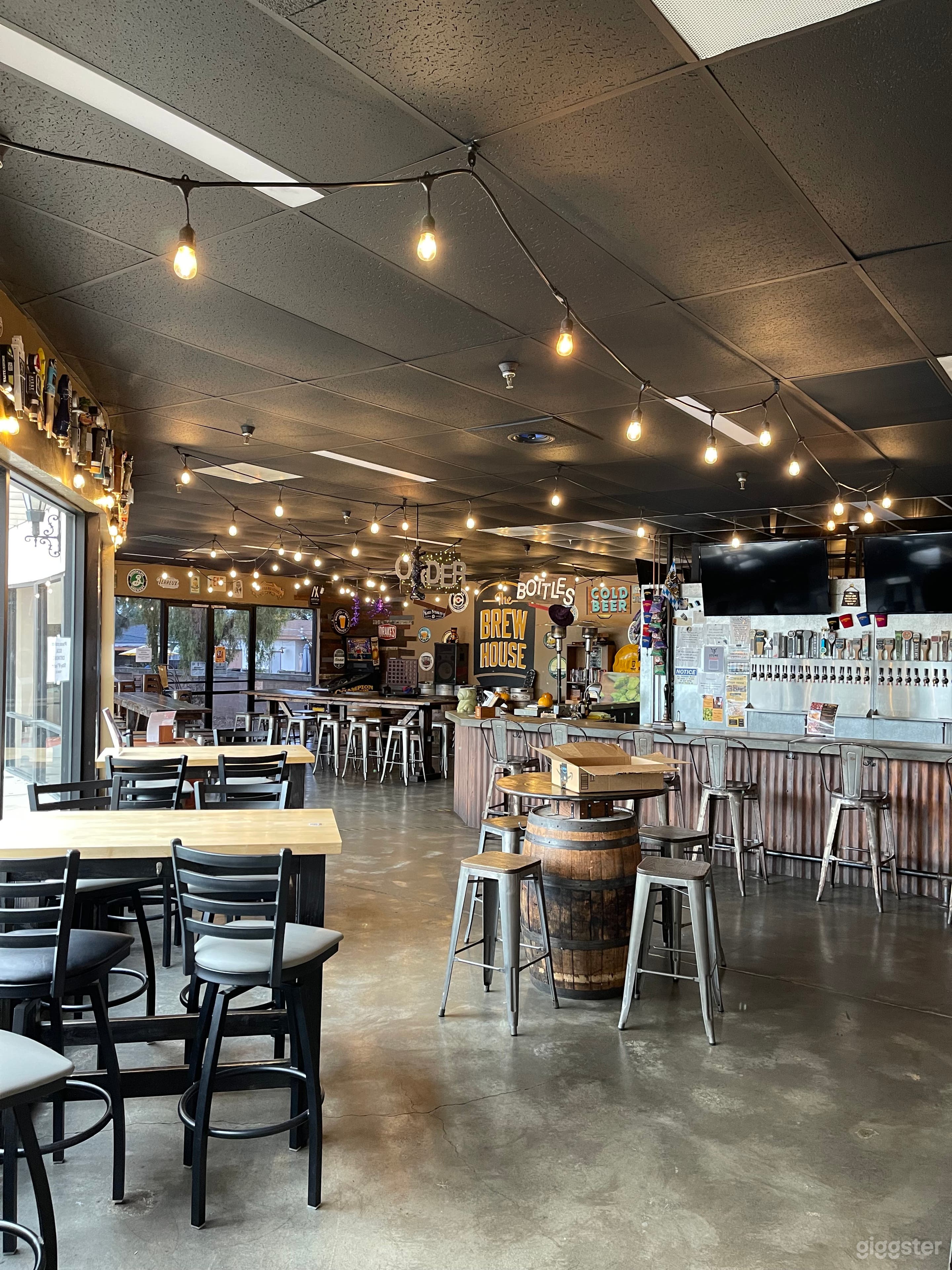 brewery style setting with communal tables and barrels for tables. 