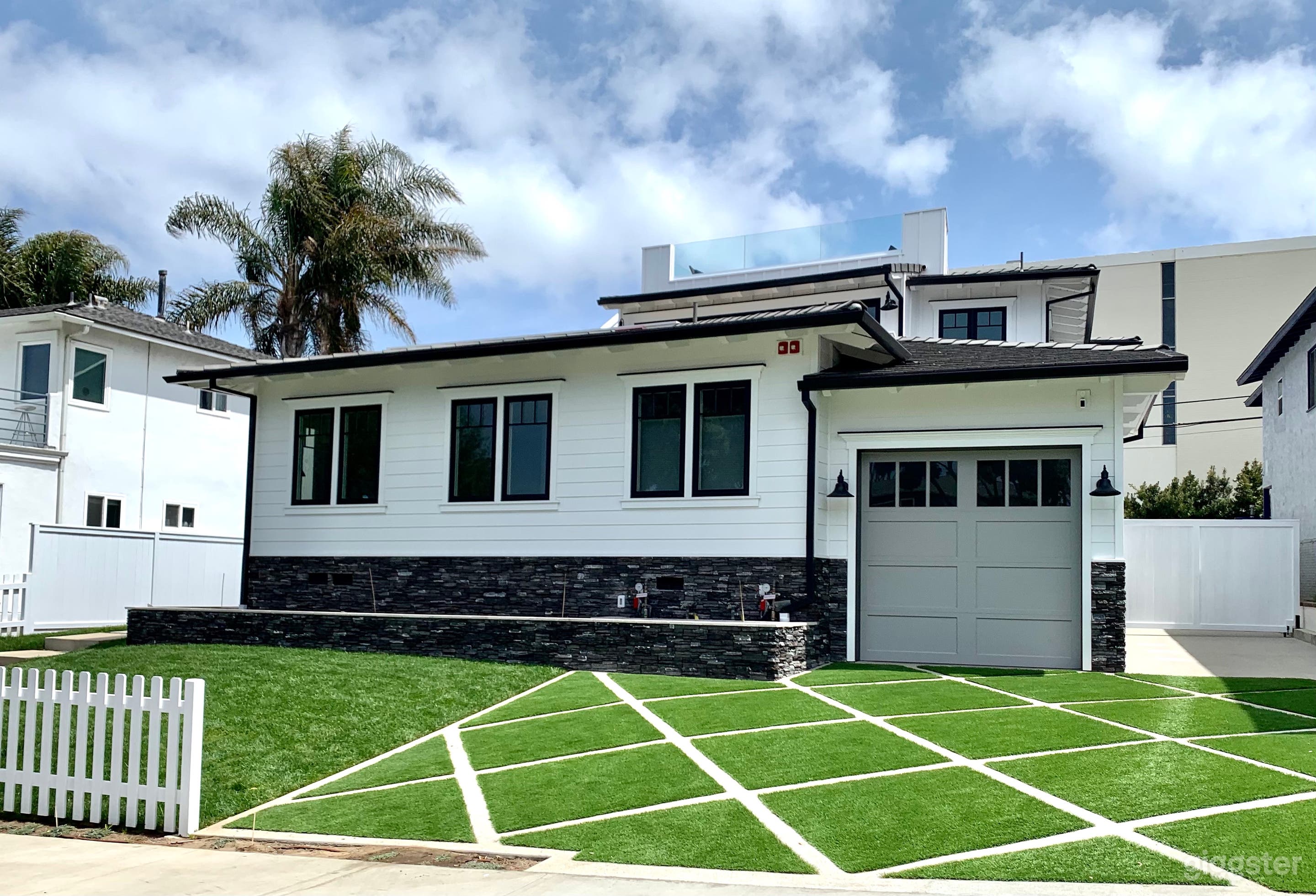 Front of the house with parking area and grass area.