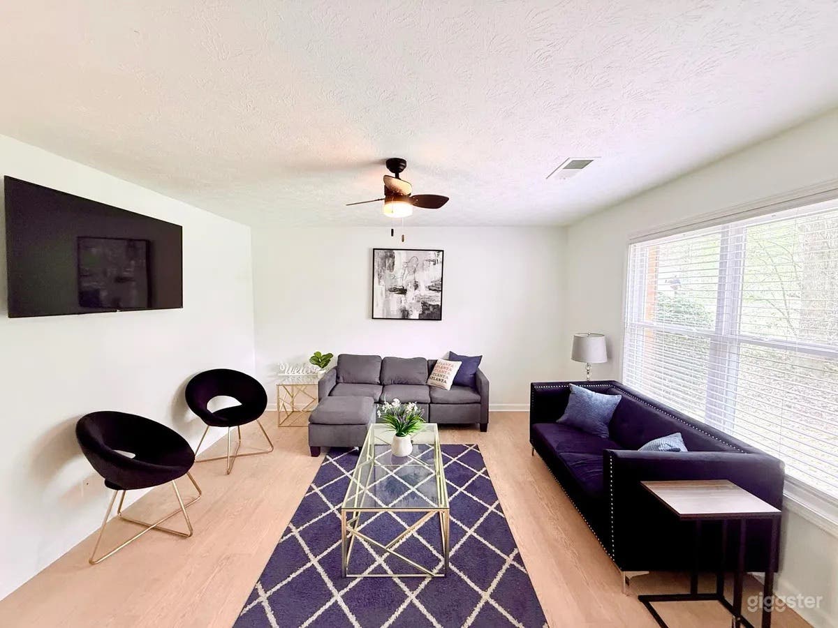 Living room with seating a TV and views of the front of the building