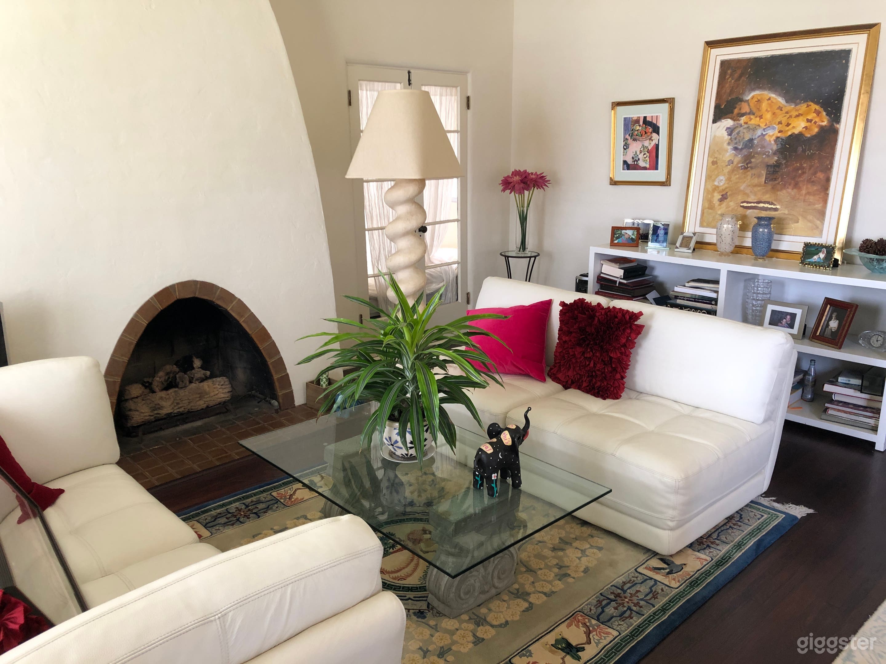 View from front door.  Back Glass door behind lamp enters office and a second back door to side patio.  Side patio is a great production set up area or staging area for talent.  Photo below.  Fireplace is gas. Arches complement home throughout.