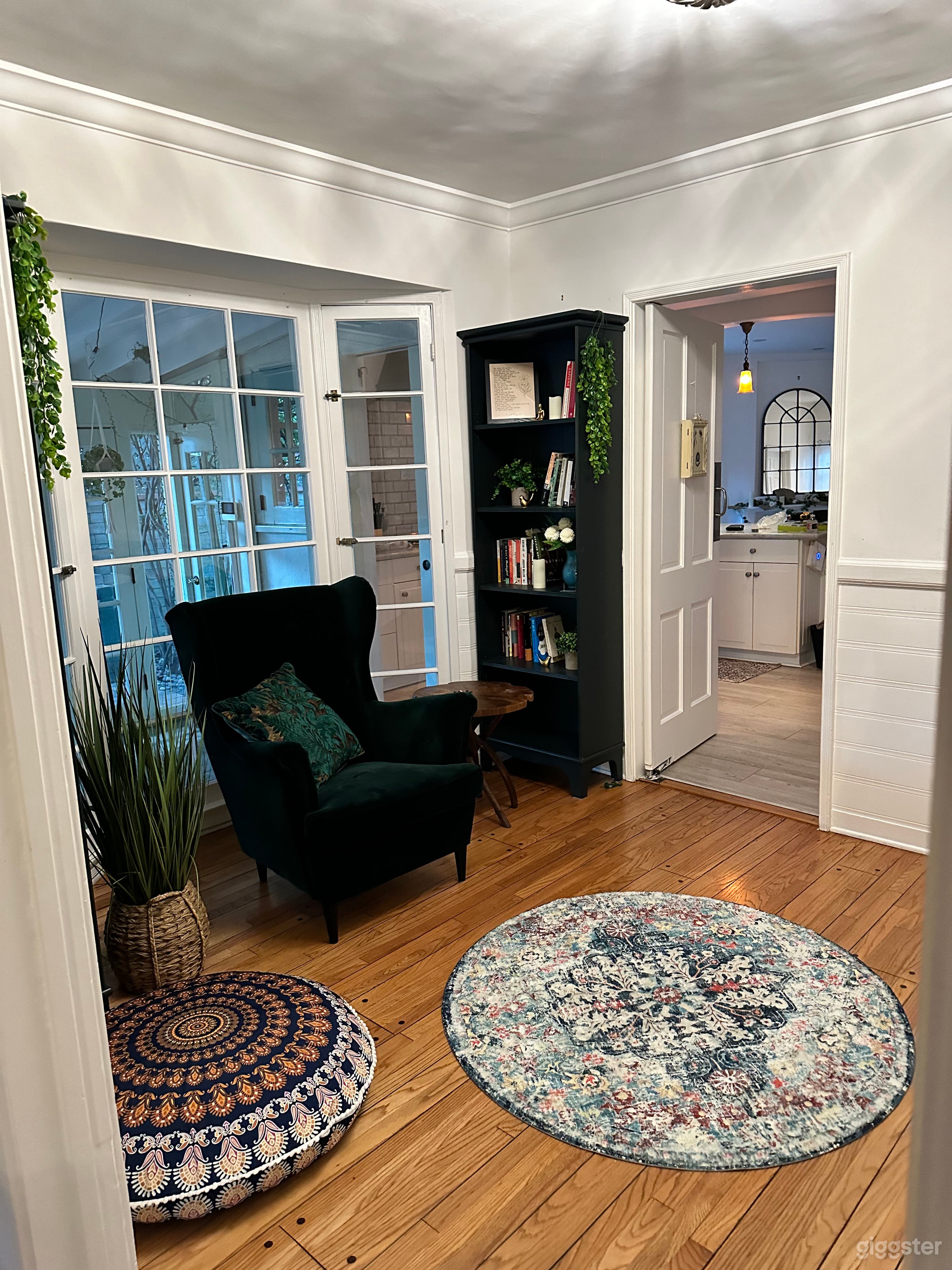 This room connects the living room to the kitchen. Formally considered a dining area, it is designed to be a reading space, with a daybed, book shelves, and a comfy velvet chair. The windows behind the chair open to the dining room on the other side.