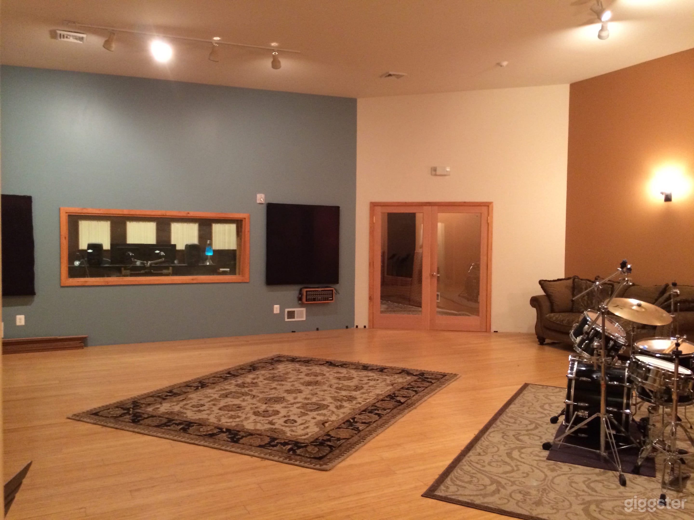 Live Room front wall with view of control room window and isolation room glass door 