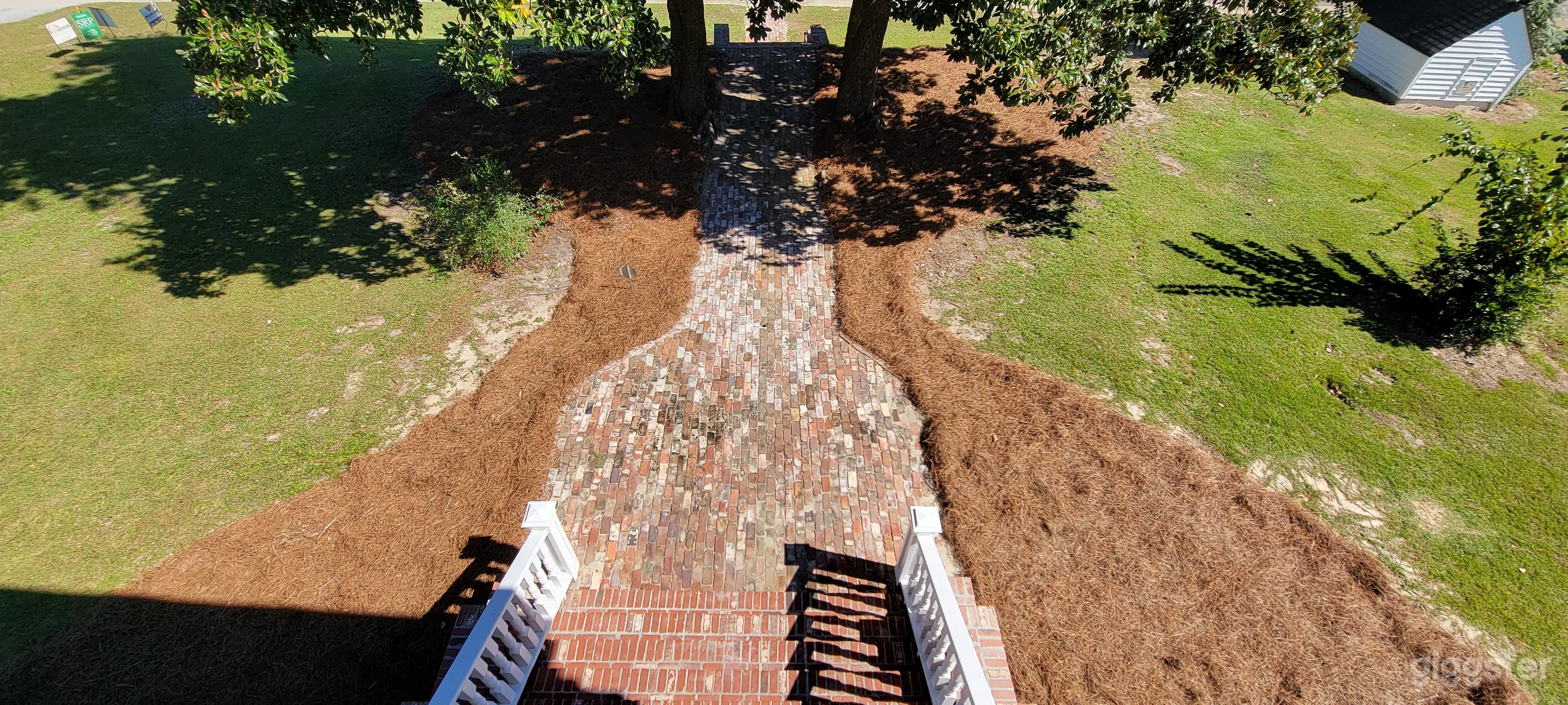 Upper front porch view of historic hand made clay bricks and historic Magnolia trees