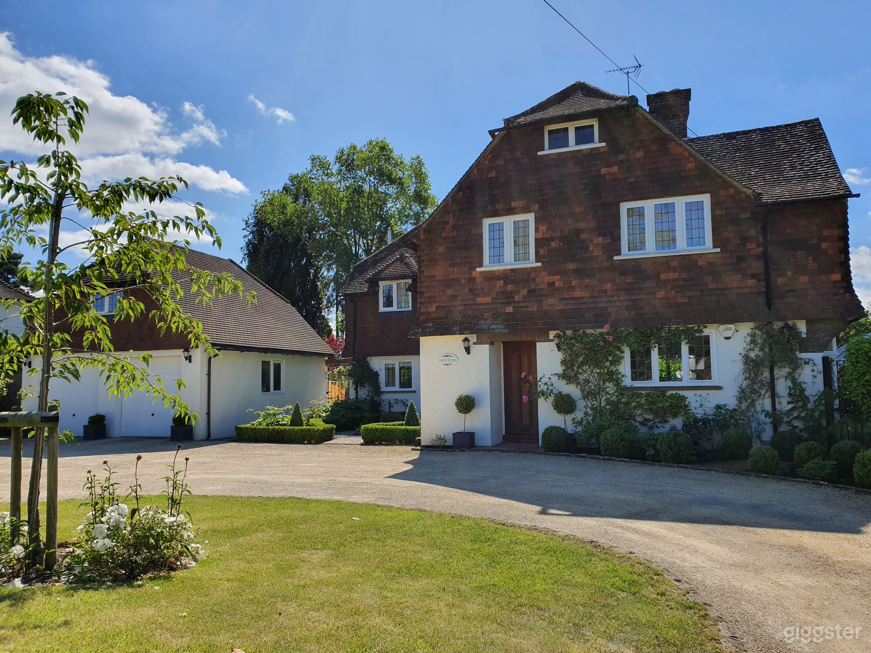 Traditional red brick facade-Quintessential English architecture with white accents and a manicured driveway. Perfect for establishing shots or promotional content. 