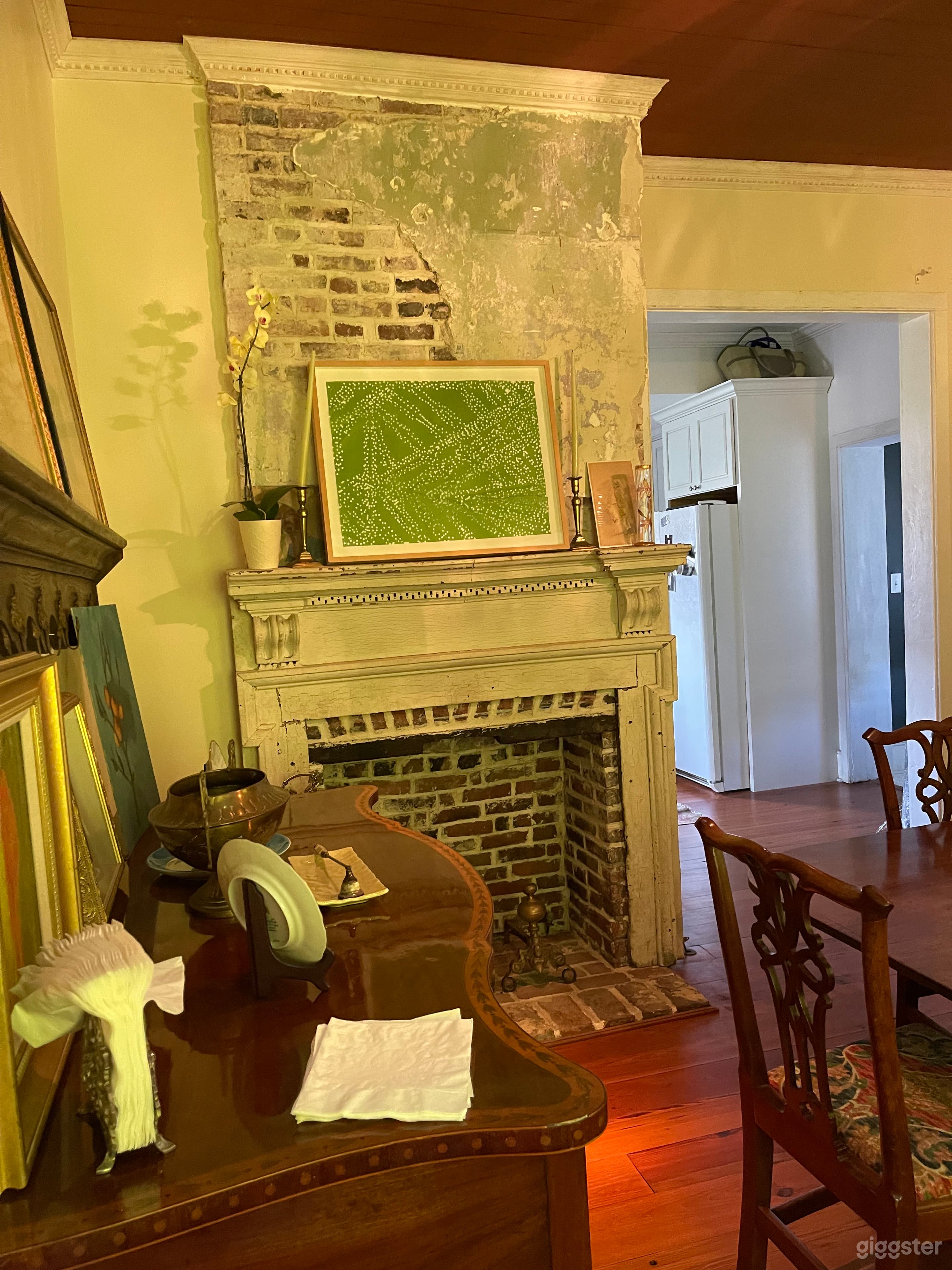 Dining room with exposed brick and a federal-period mantel.