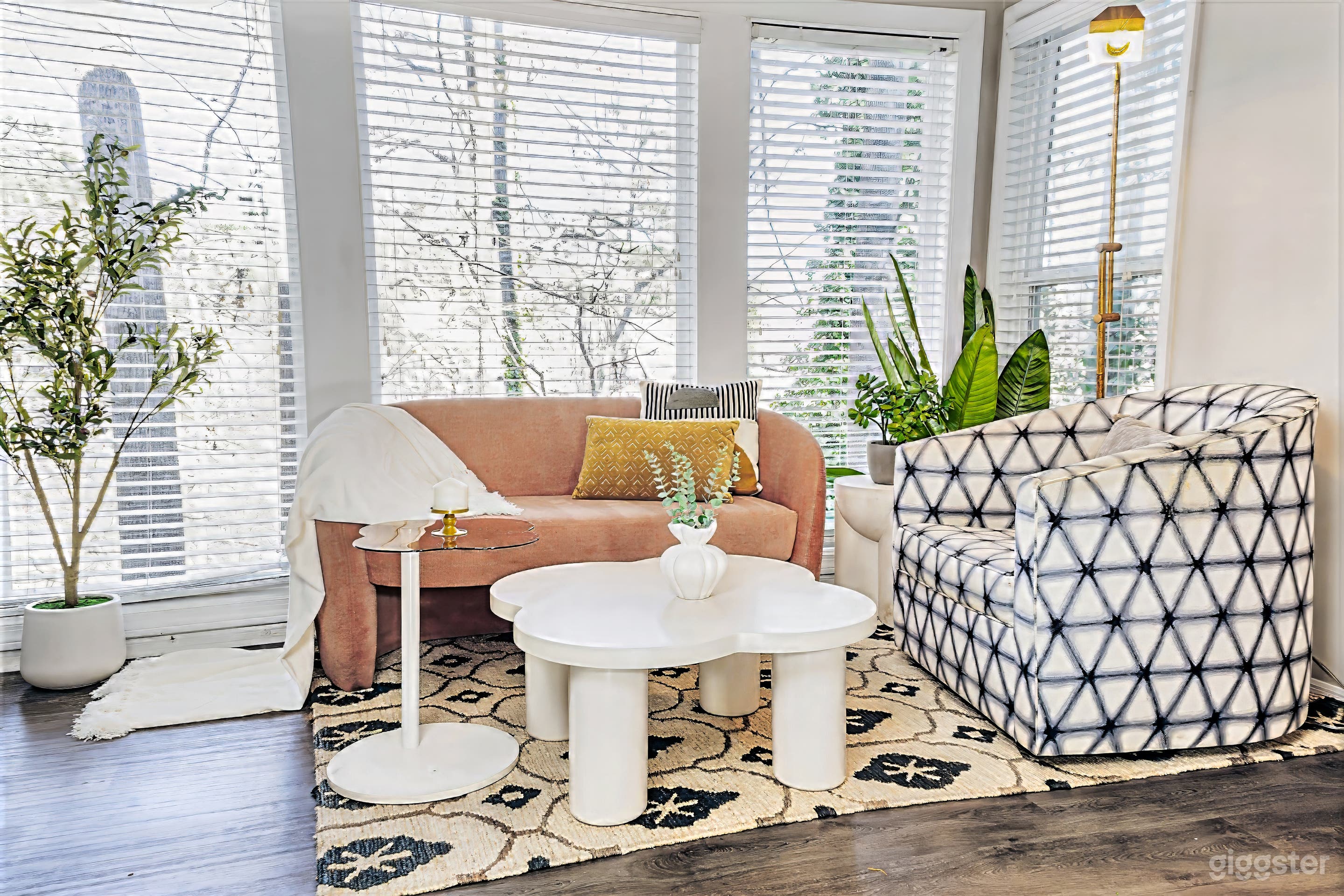 Natural-light seating area framed by floor-to-ceiling windows and a wooded backdrop, ideal for portraits, UGC, interviews, and lifestyle shoots.