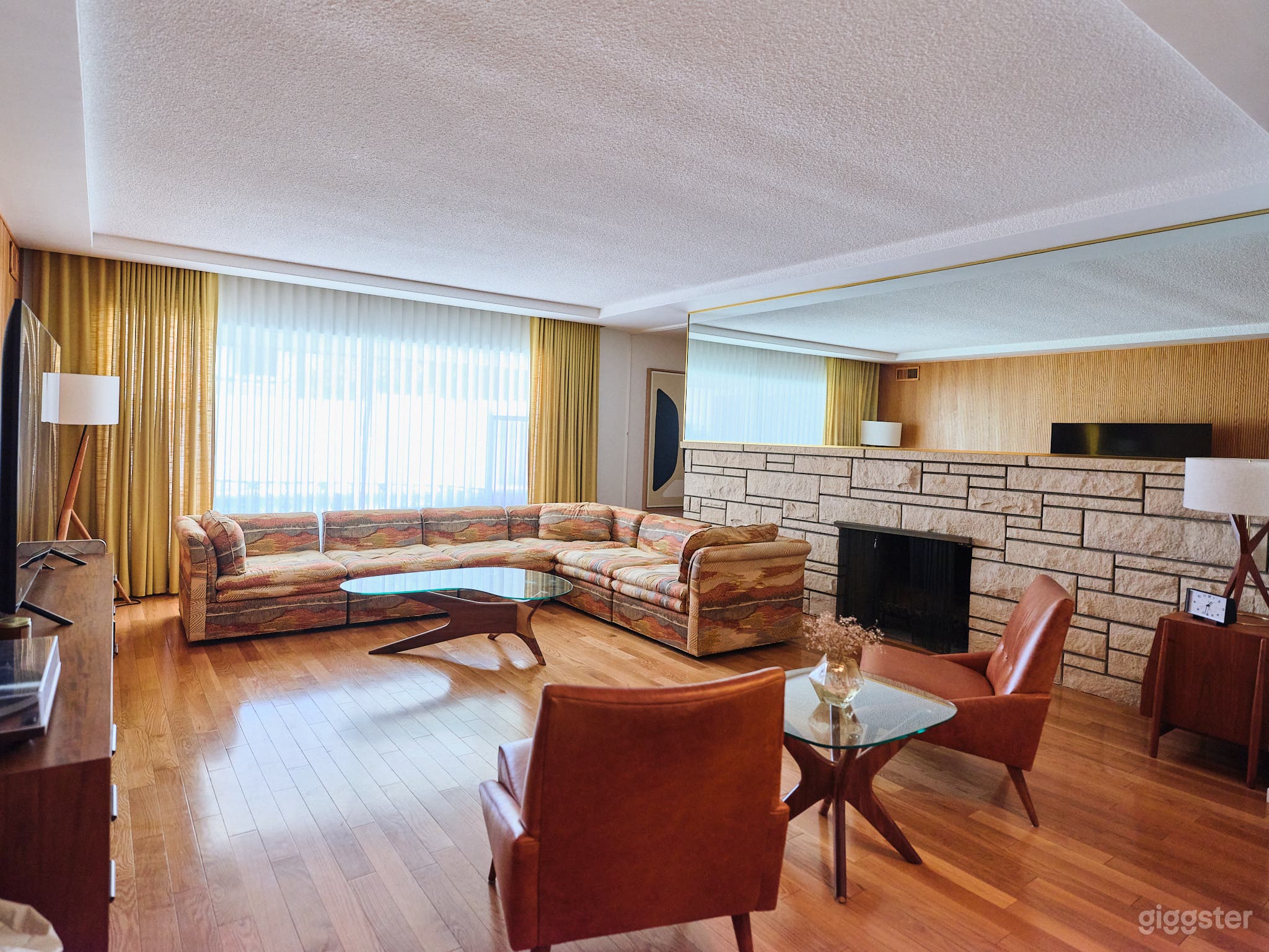 updated image. Living room #1 | Wood panel wall opposite stone fireplace. Window draping and sheers are floor to ceiling length. 