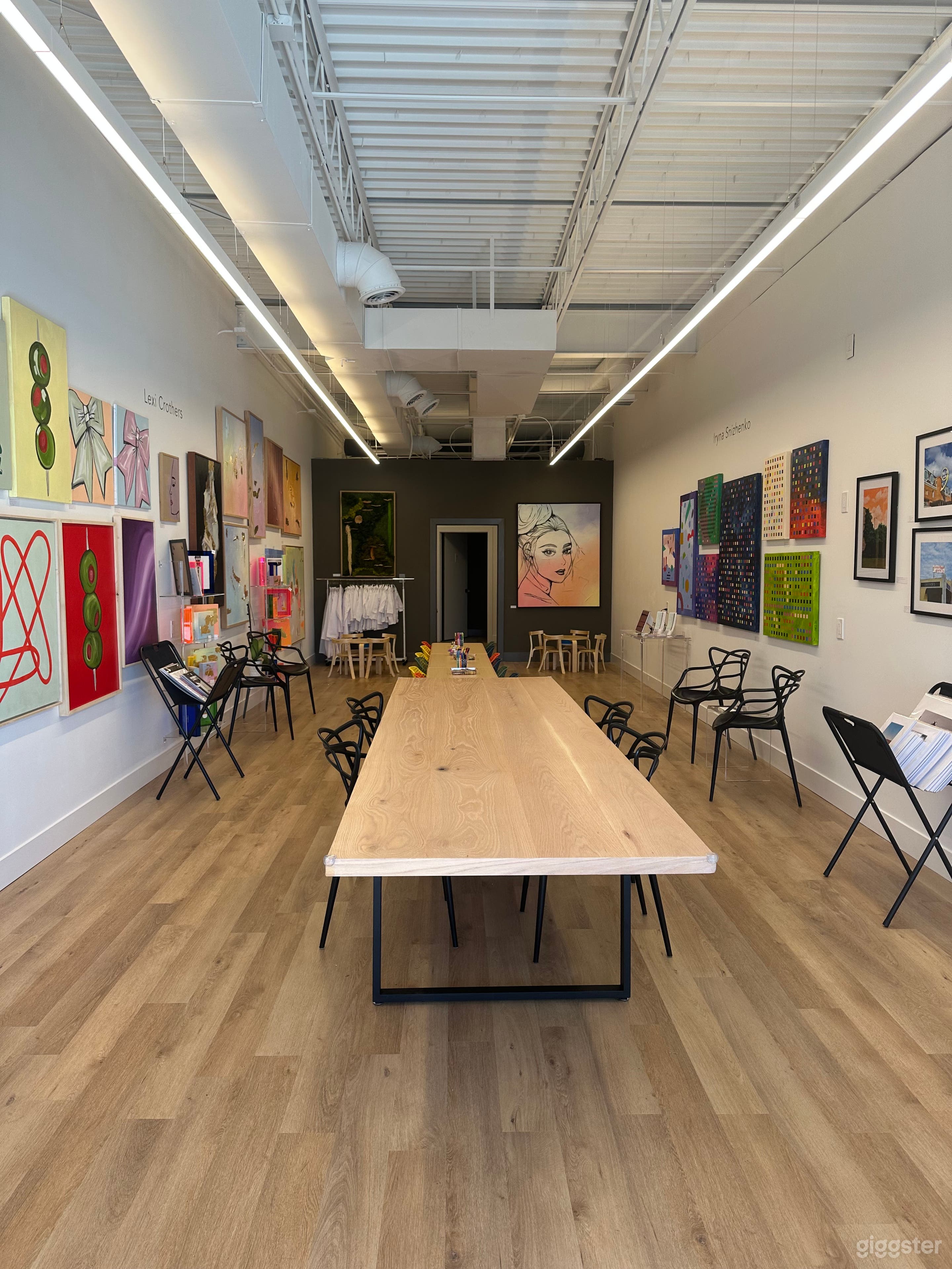 View from front of gallery. Gallery is approx 850 SF. Chairs and kids tables can be removed. Large 12’ x 36”red oak table cannot be moved. Art may be removed from walls for an extra fee. Two large Bluetooth Speakers on back wall available for use. 