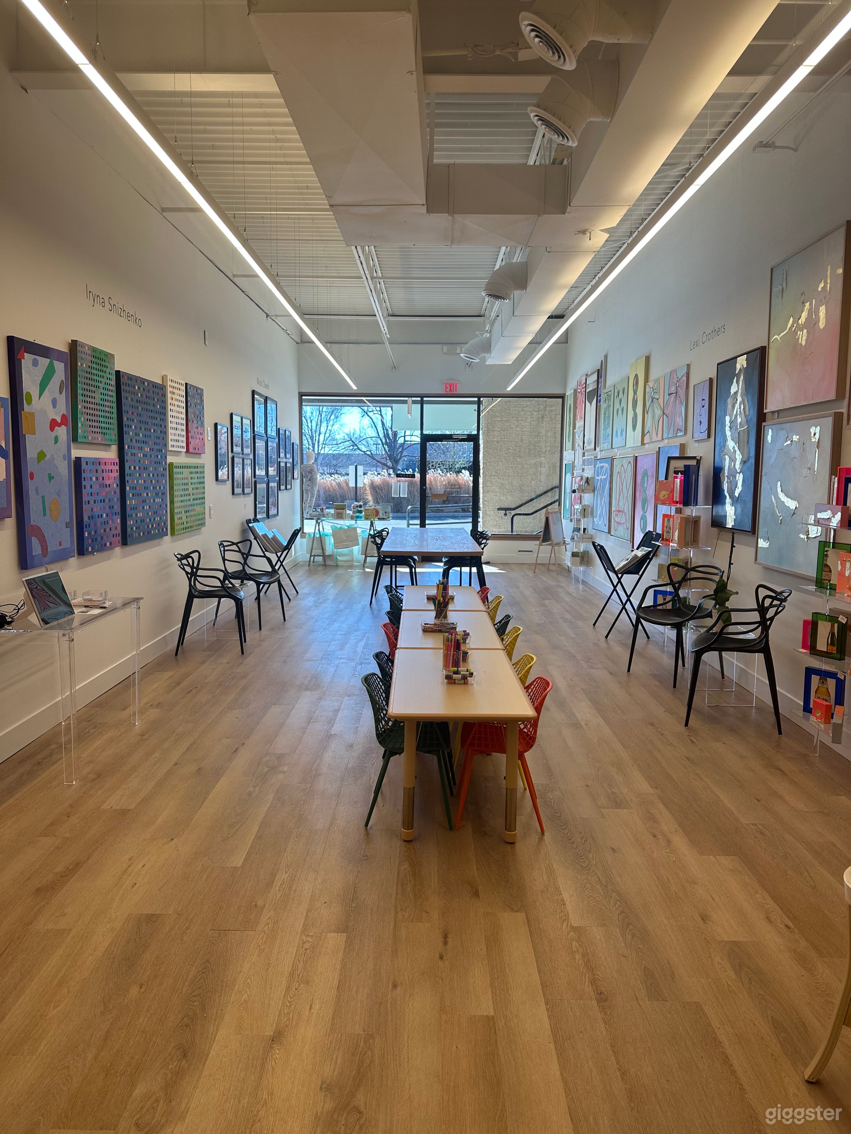 View from back of gallery. Gallery is approx 850 SF. Chairs and kids tables can be removed. Large 12’ x 36”red oak table cannot be moved.