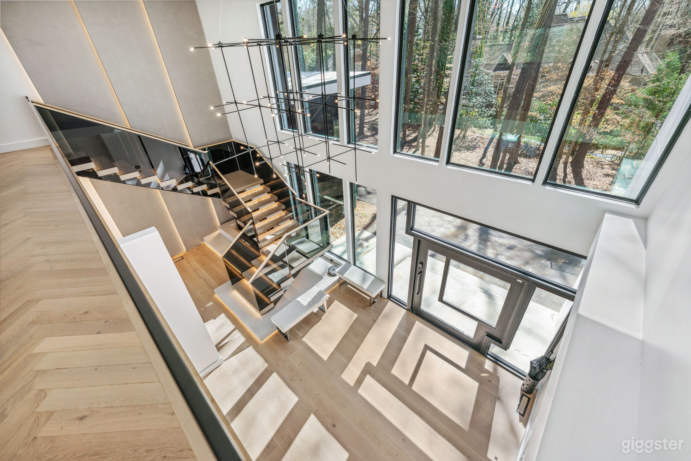 Modern Luxury Foyer
This striking entryway features a grand modern pivot door that opens into a light-filled, minimalist foyer. A Venetian plaster feature wall adds a touch of elegance, while the showcase staircase is accented with LED-lit steps.