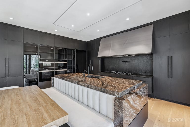  Luxury Kitchen with Hidden Cooktop
This chef-worthy kitchen showcases custom cabinetry, high-end Miele appliances, and a striking stone island with built-in banquette seating. 
 