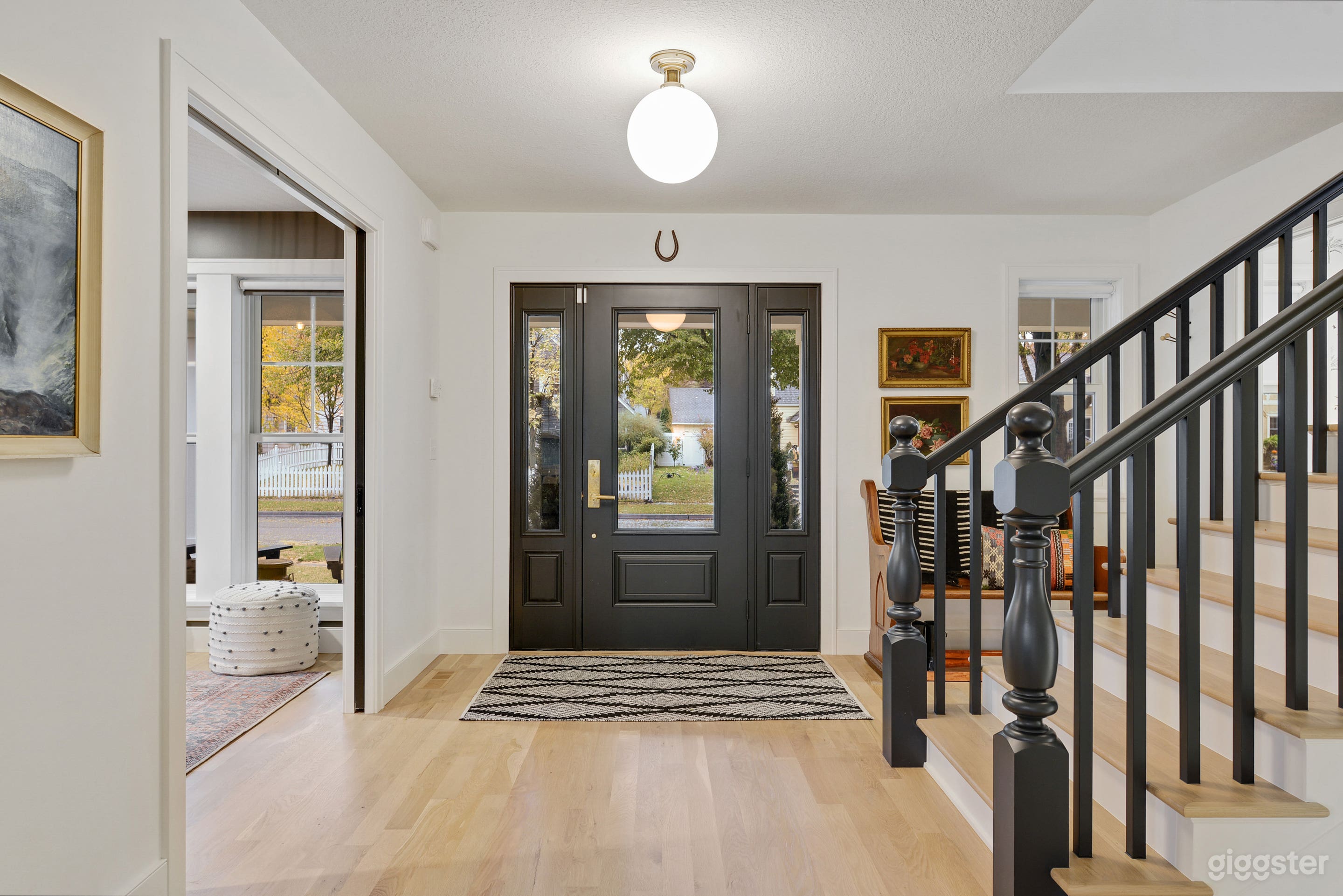 Entry shows home office to the left, powder bath to the right; real hardwood floors. Vintage art throughout.