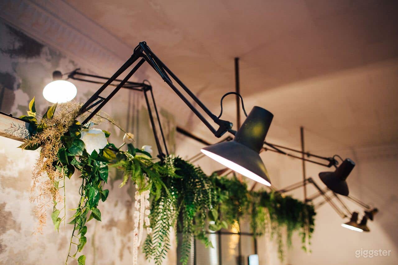 Beautiful vintage lights with greenery above leather lounge dining area