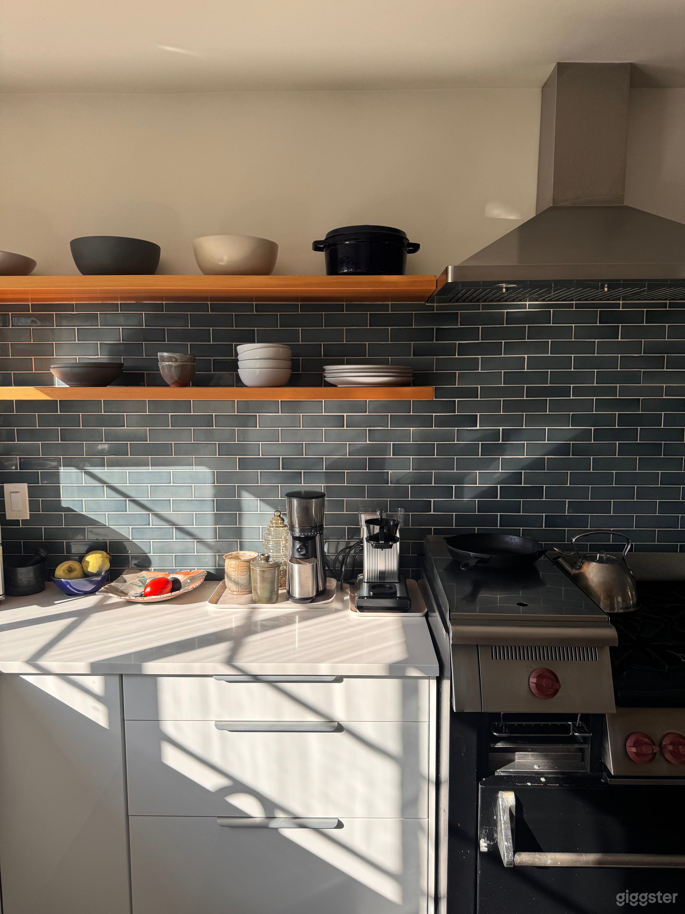 Bright kitchen with marble counters, open shelving, and Heath tile backsplash — a natural-light, modern California kitchen ready for film or photography.
