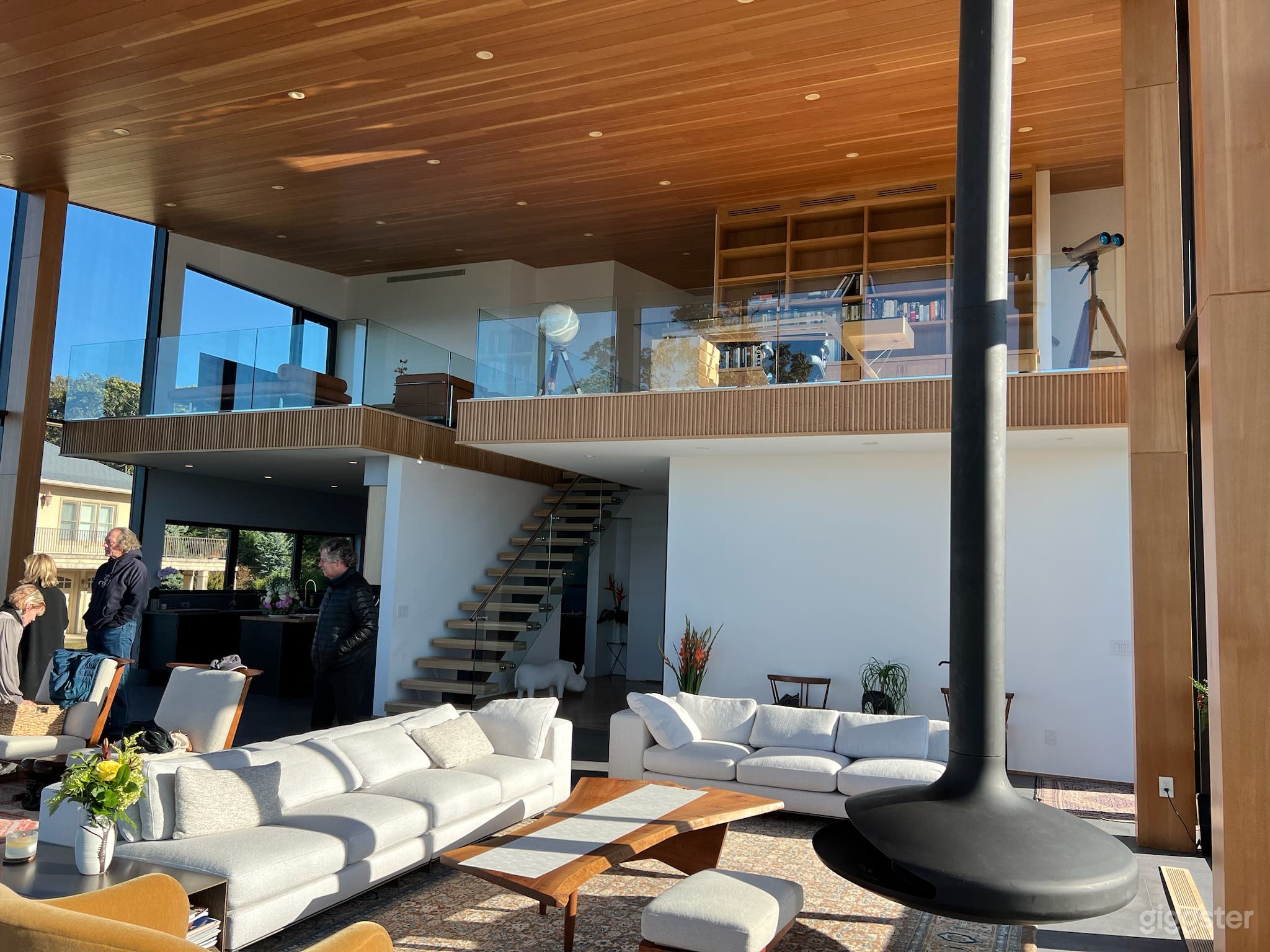 The living room has an open floorplan and hanging fireplace.