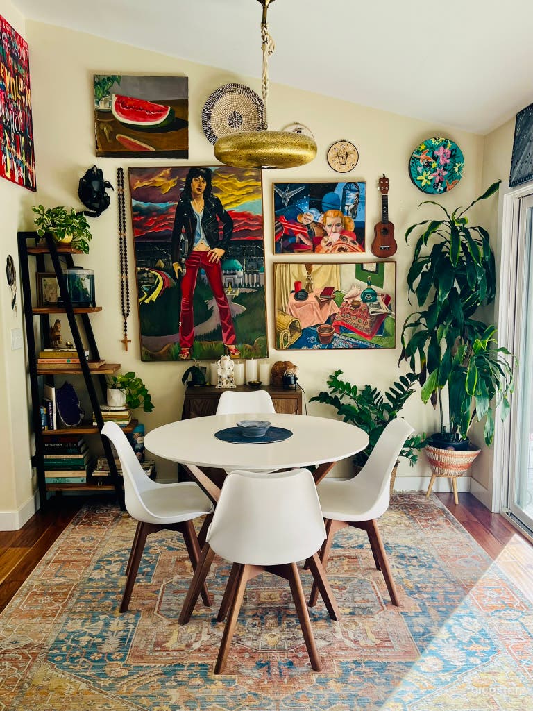 Eclectic dining area surrounded by original artwork, instruments, and lush greenery. Ideal for lifestyle or interview shoots, creative conversations, and scenes that call for artistic depth and personality. 