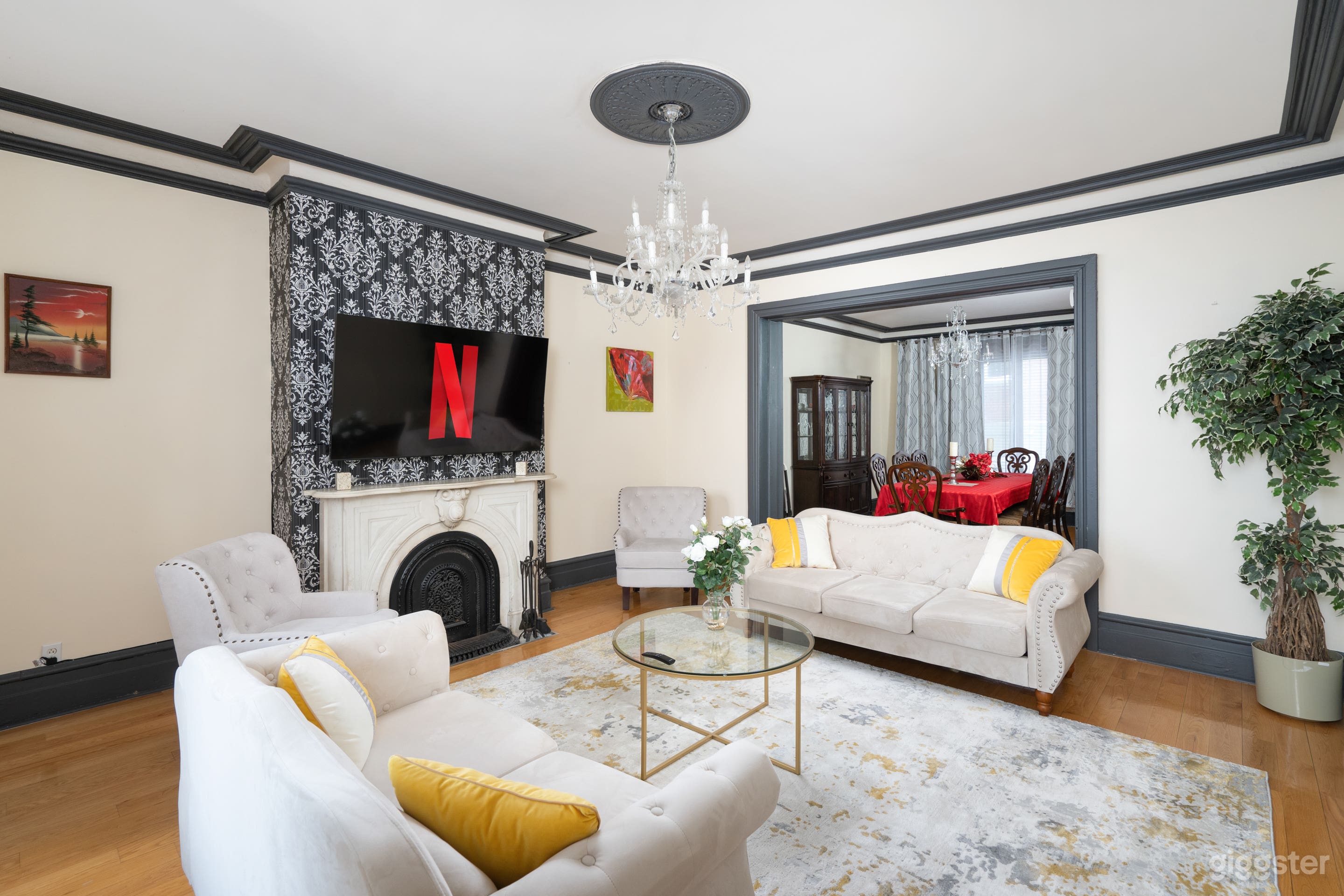 Immense living space bordering the dining area that features a 65 inch QLED TV with Netflix above a century-old marble fireplace.