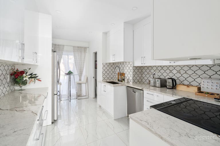  Gorgeous white glossy modern kitchen fully equipped with an exit onto the rear balcony. 