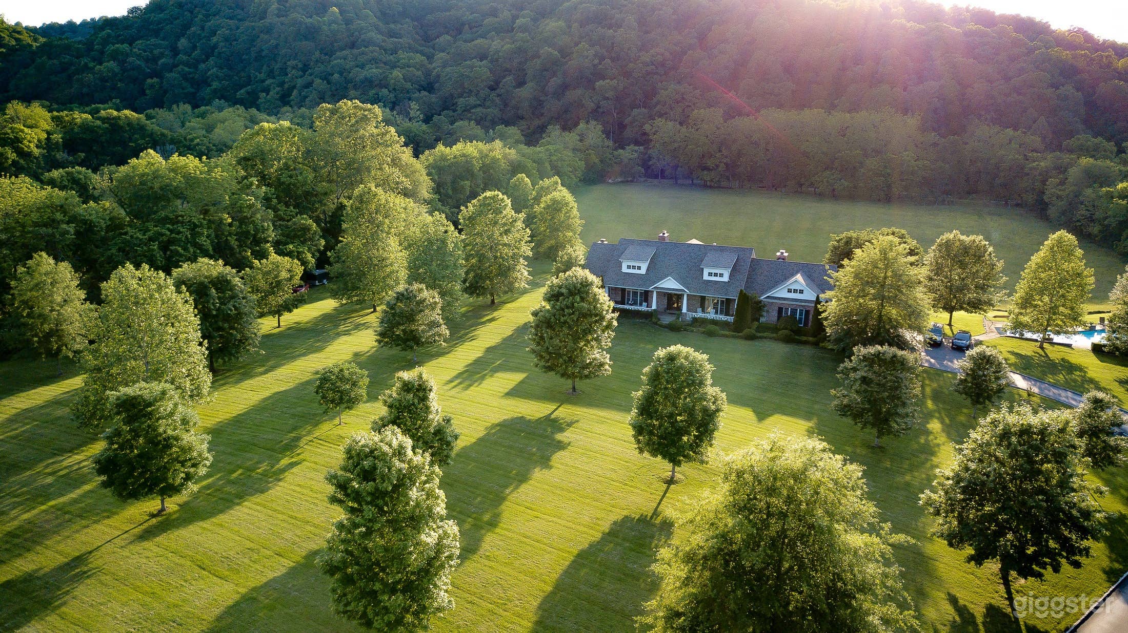 Another view of the front of house in the late afternoon as the sun is setting behind the hill 