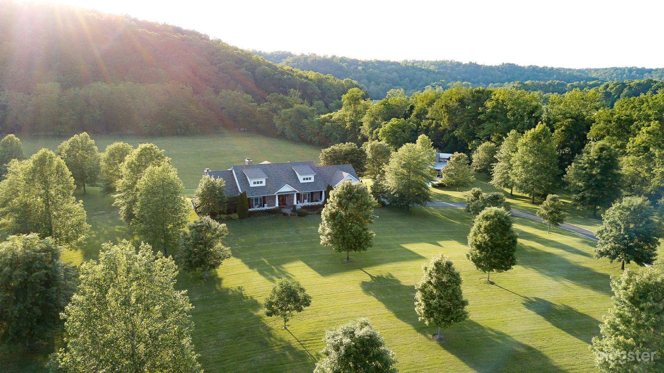 Front of house in the late afternoon as the sun is setting behind the hill 