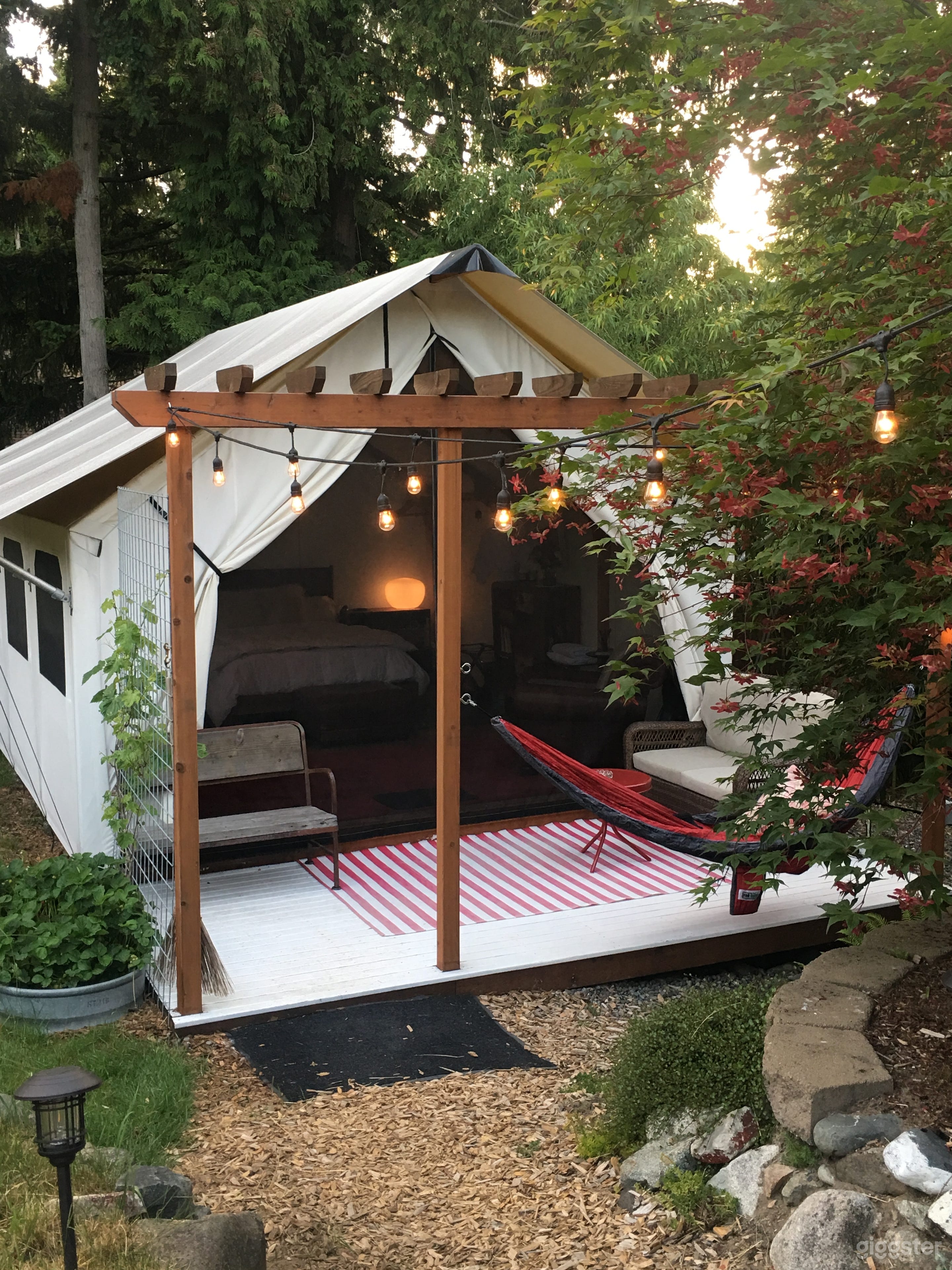 Wall tent lounging area with kitchenette and mini fridge.