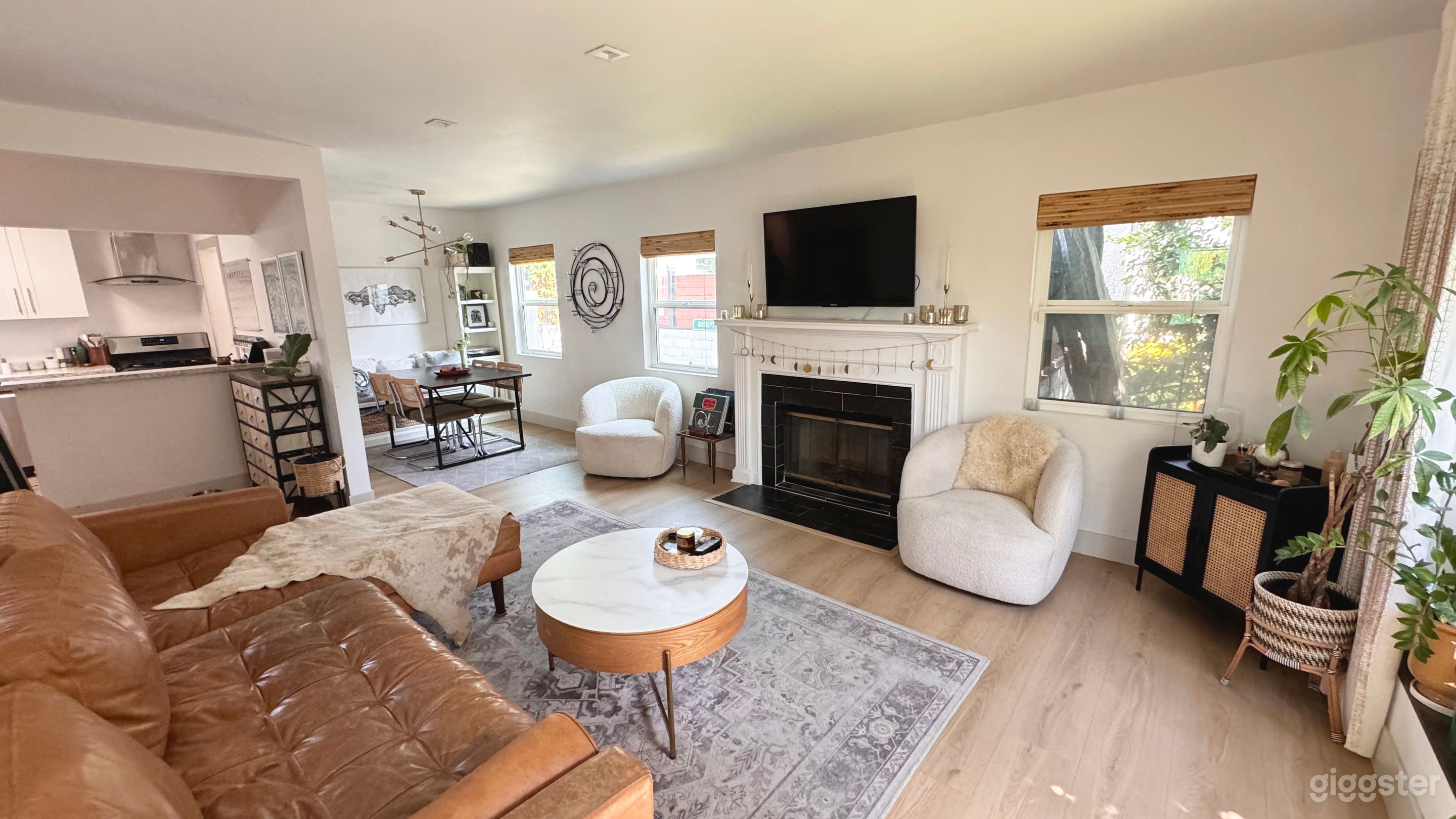 Living room with leather sofa, fireplace, bar, boucle chairs and record player